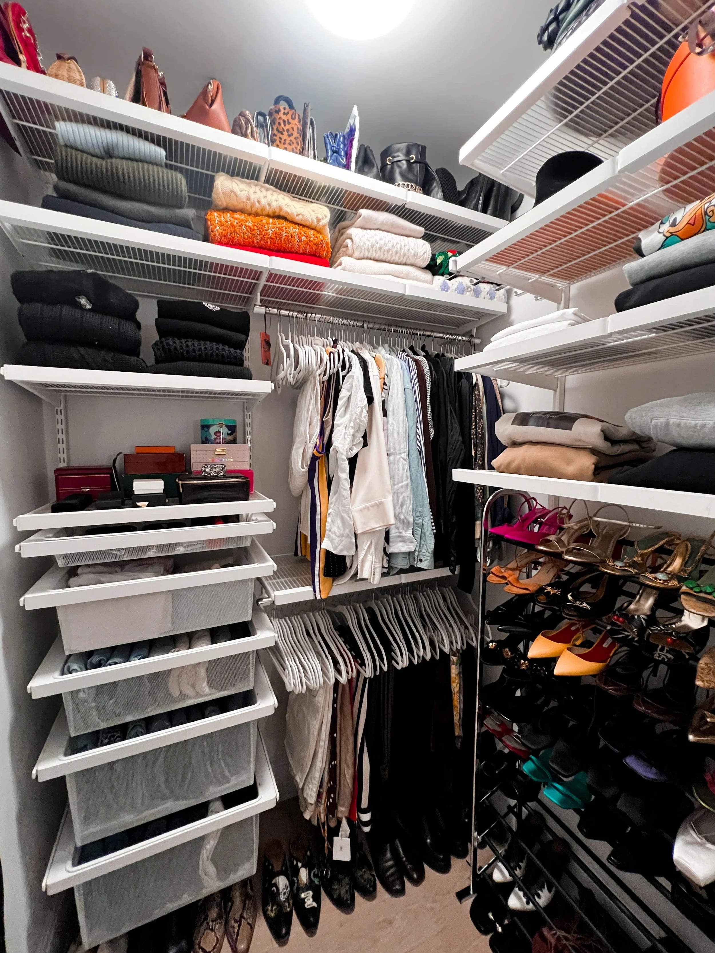 Organized primary closet with folded and hanging clothes