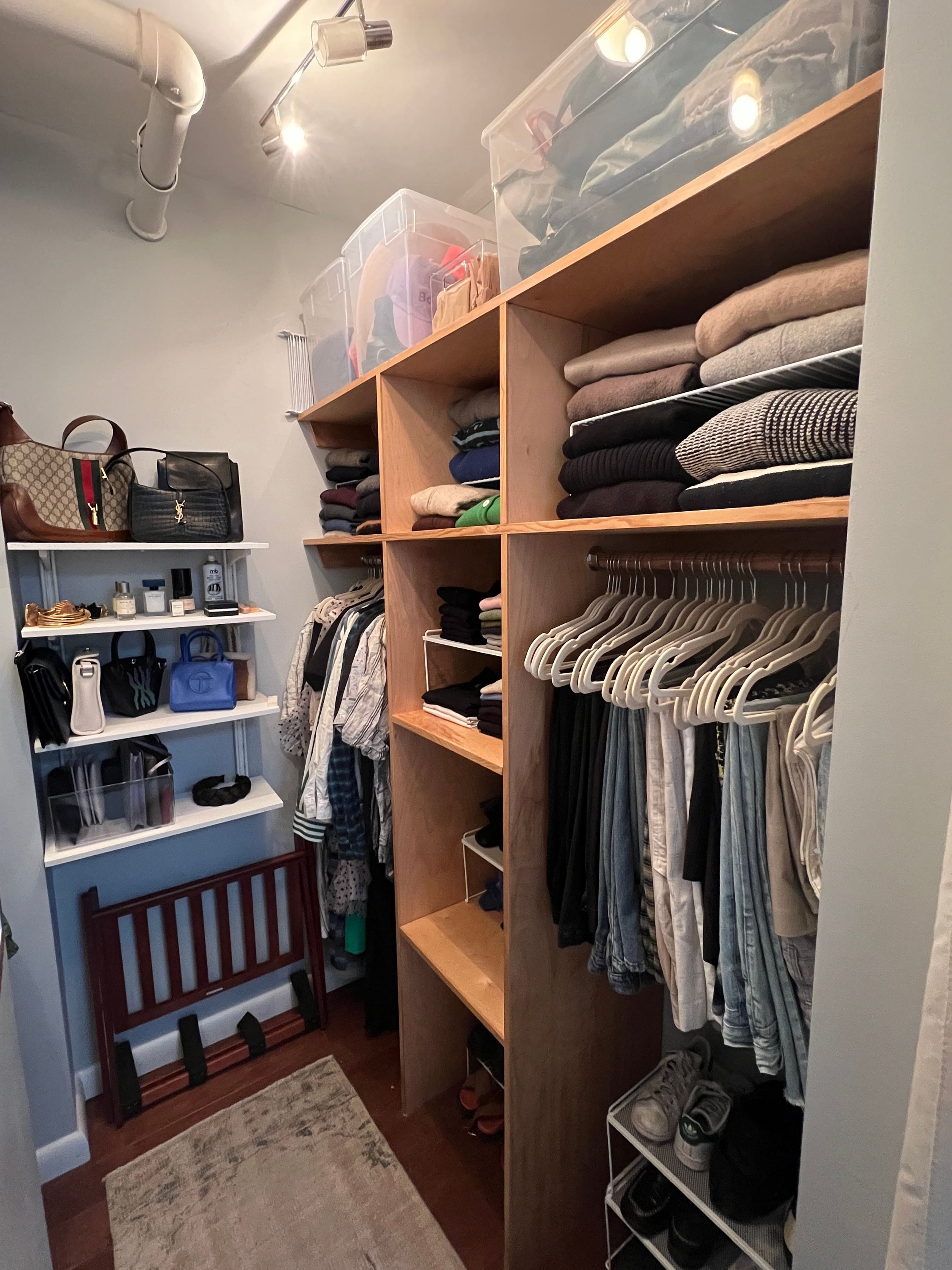 Orderly closet with matching hangers and folded clothing. 