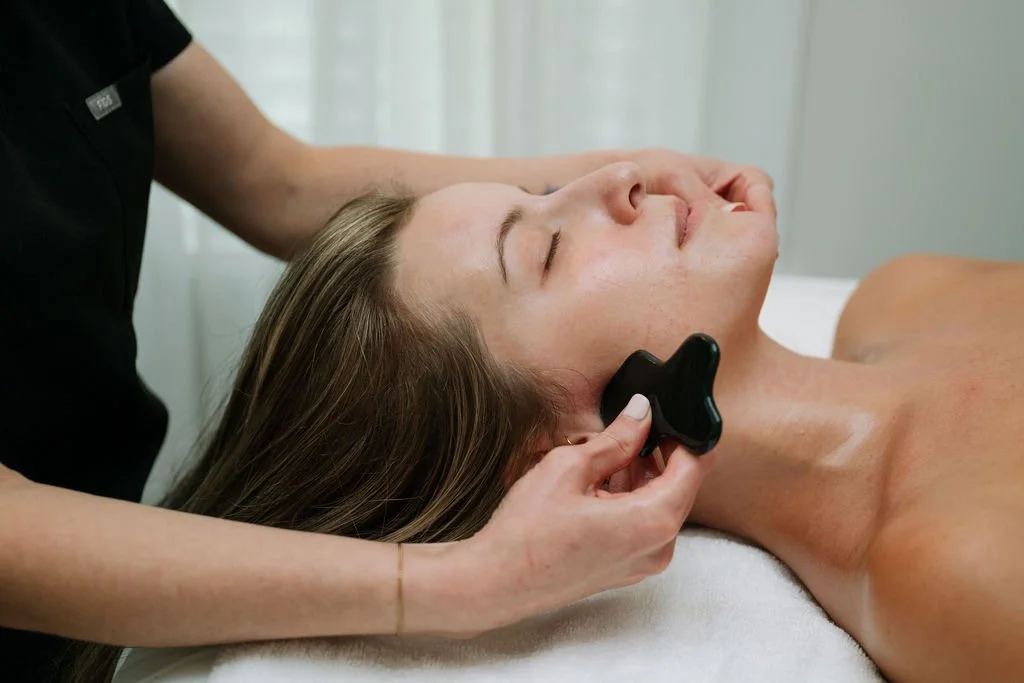 facial gua sha tool with oil and crystals