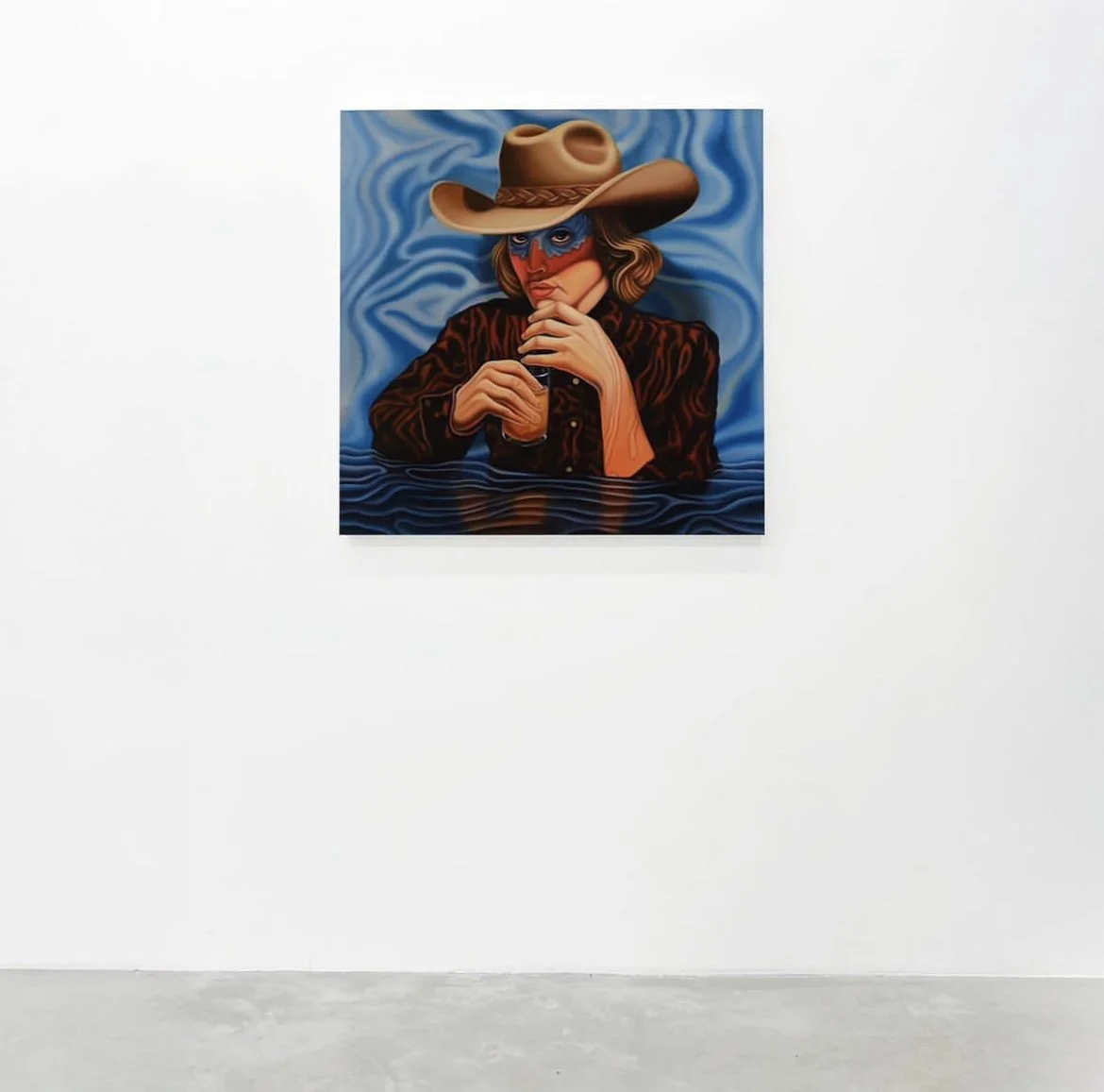 Painting of a woman wearing a cowboy hat, mask, and a patterned jacket, holding a drink, with a water rippling effect on the surface and a blue cloudy background.