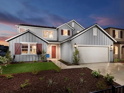 The exterior of a large home for sale in Keyes, CA. The photo depicts a multi-story home with red window shutters, a white garage door, and a light stone grey siding.