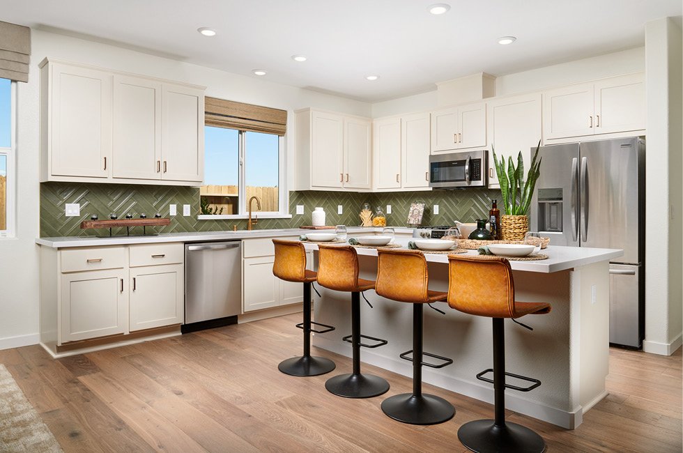 Gorgeous kitchen with kitchen island, included appliances, white cabinets, beautiful backsplash and more. This is our Residence one at Marcona in Keyes, California