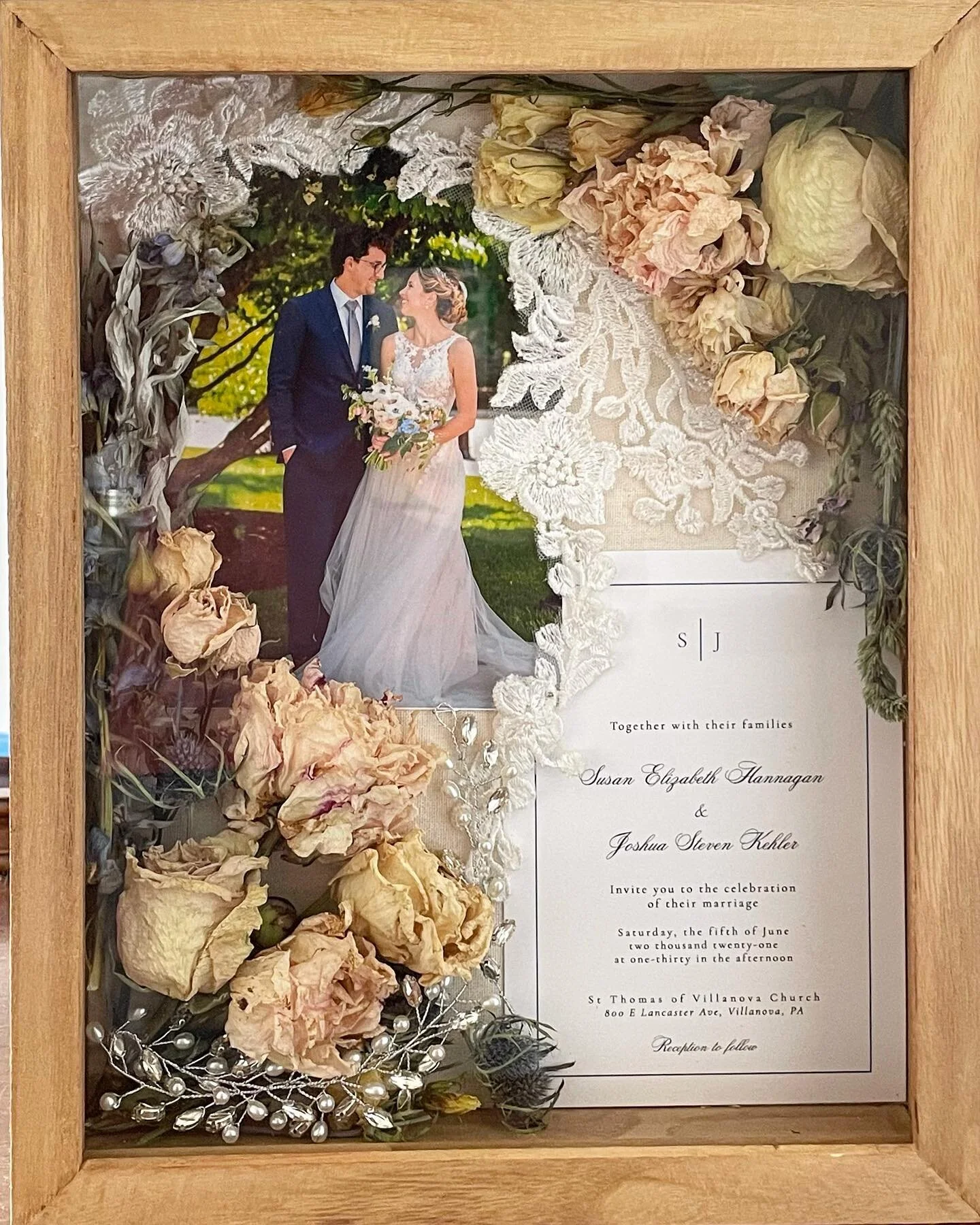 Shadow box featuring bouquet flowers the bride dried herself, along with photo, invitation, lace from her dress, and a jeweled hairpiece she wore to her wedding.
