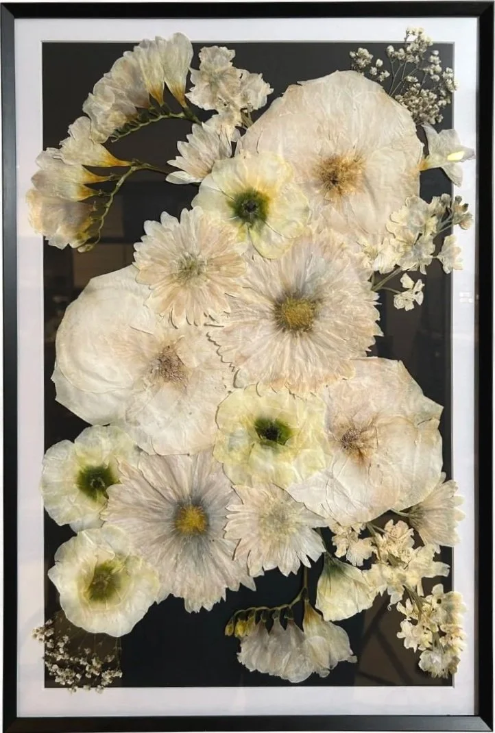 12x18 black metal frame with black background and white mat, featuring white roses, lisianthus, and freesia - Color corrected. (Assymetrical stacked design)