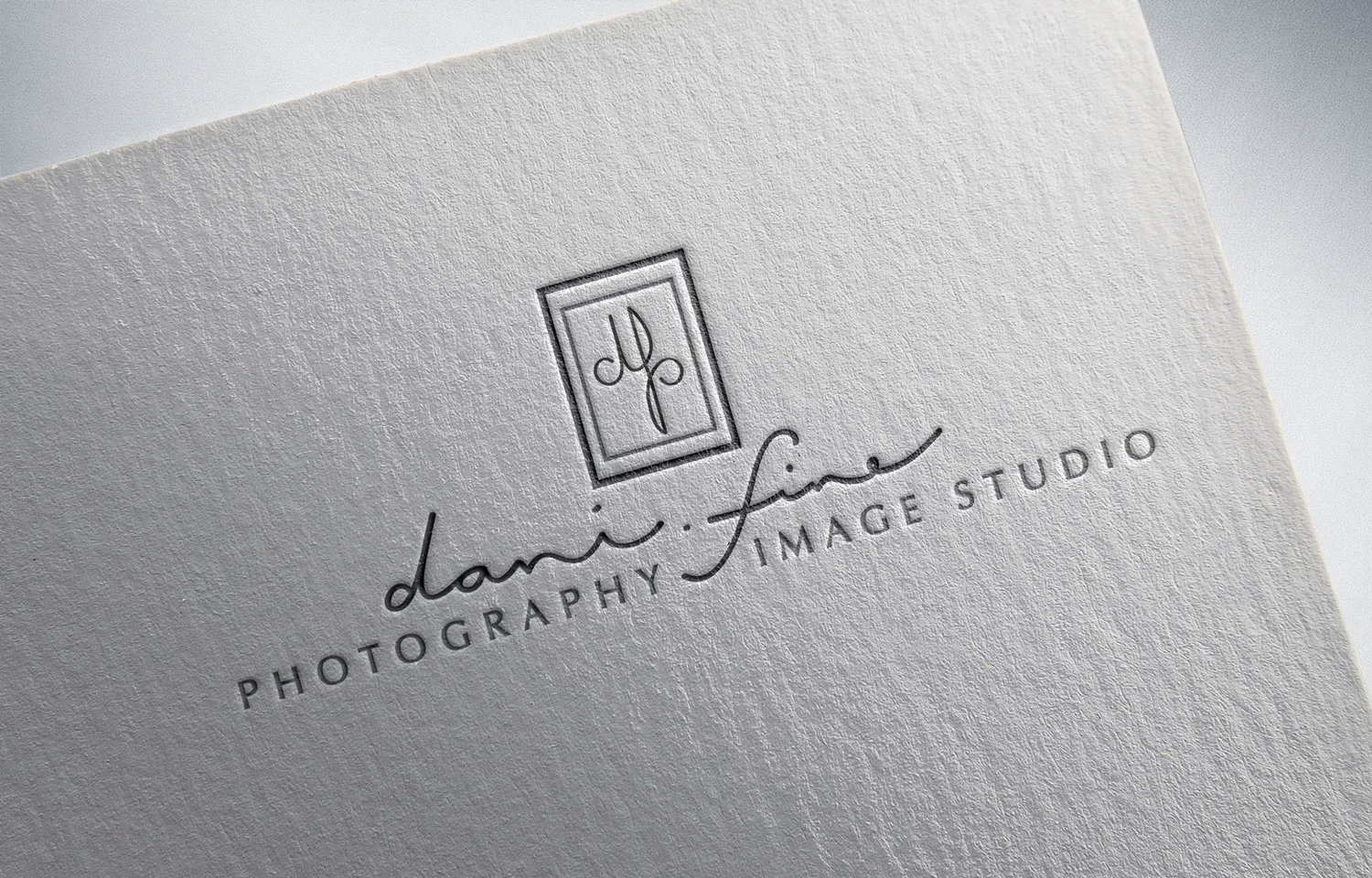  a hand lettered logo design for a photography studio with elegant letters and a clean appearance. The logo is displayed on a letterpress business card and reads dani. fine photography and image studio 
