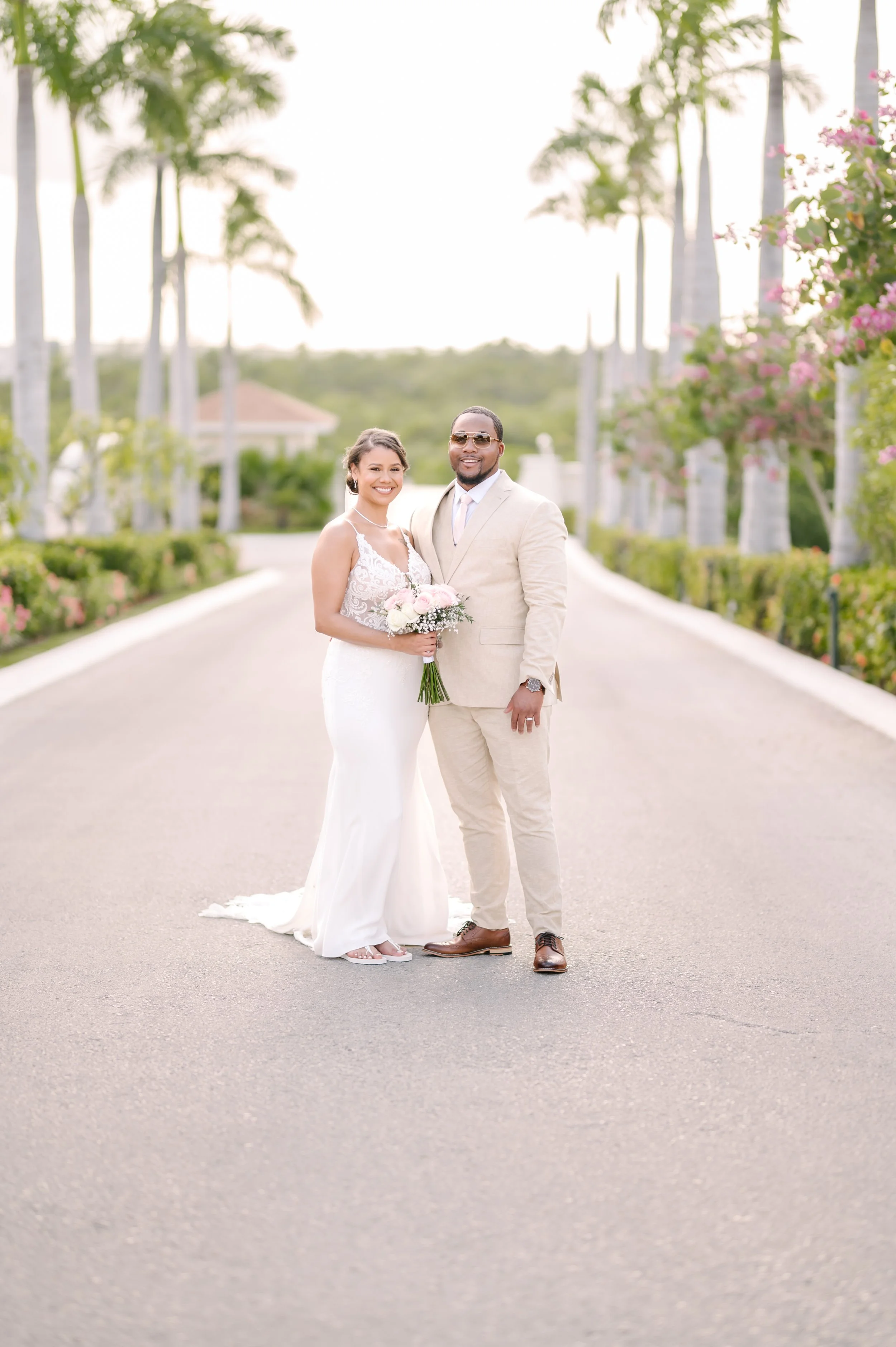 Bride and Groom taking a wedding portrait with palm trees in the background at Secrets Resort in Cancun, Mexico.