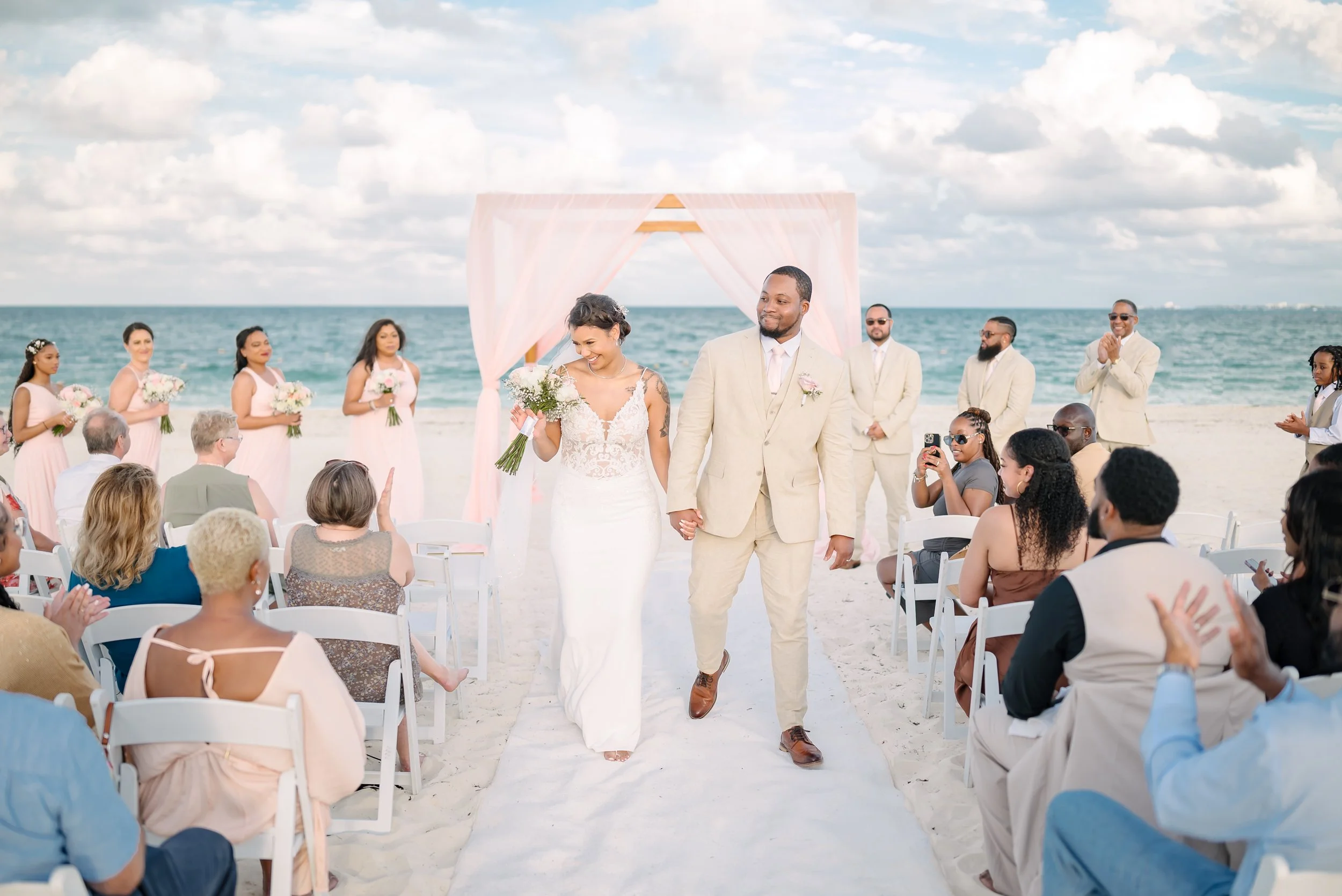 A bride and groom leaving the ceremony at a wedding ceremony at Secrets Resort in Cancun, Mexico.