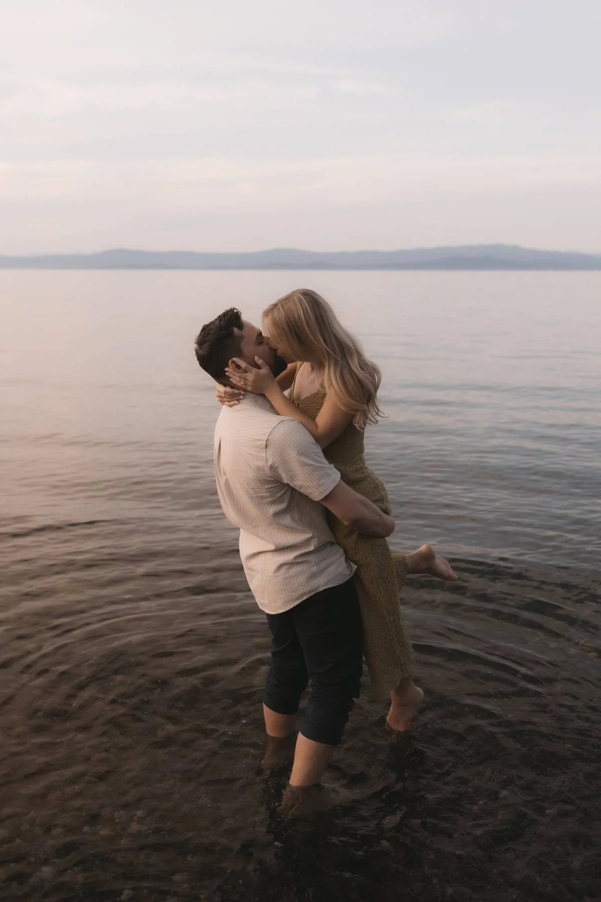 Couple embracing in the ocean during golden hour engagement photos in Parksville BC