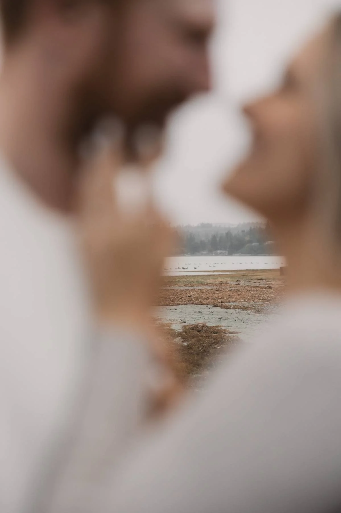 Close up couple portrait with beach and Salish Sea in the background during a Parksville engagement session
