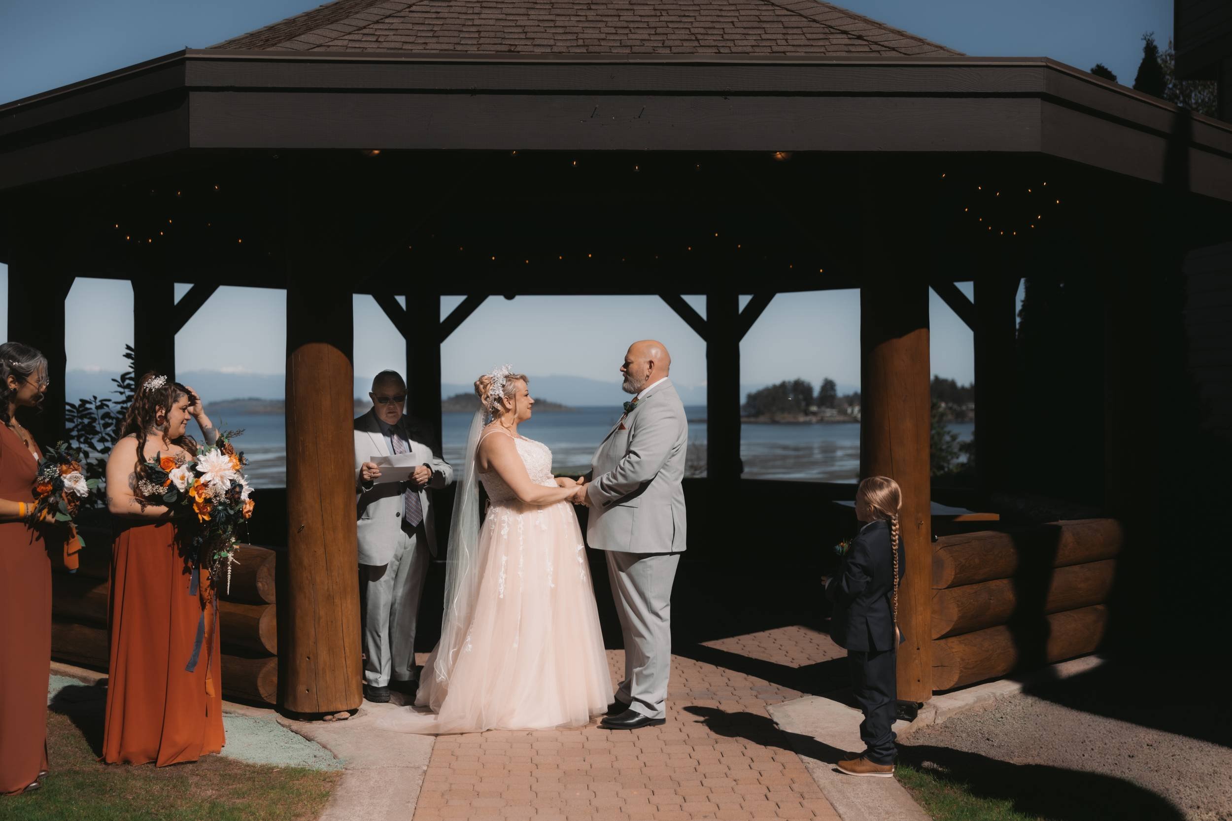 Wedding ceremony beneath the timber Seaside Gazebo at Tigh-Na-Mara in Parksville