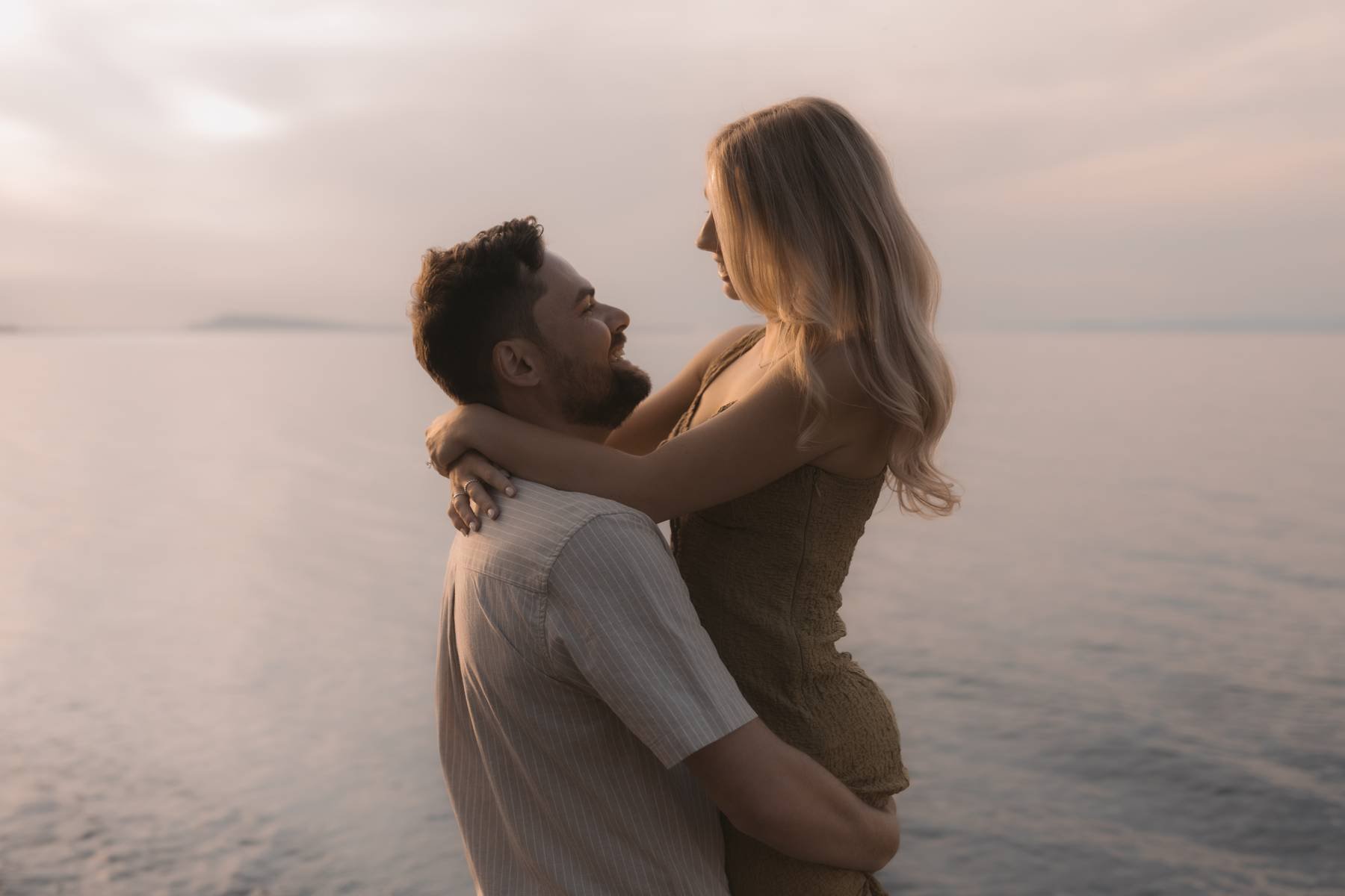 Couple embracing during golden hour engagement photos along the Parksville coastline in British Columbia