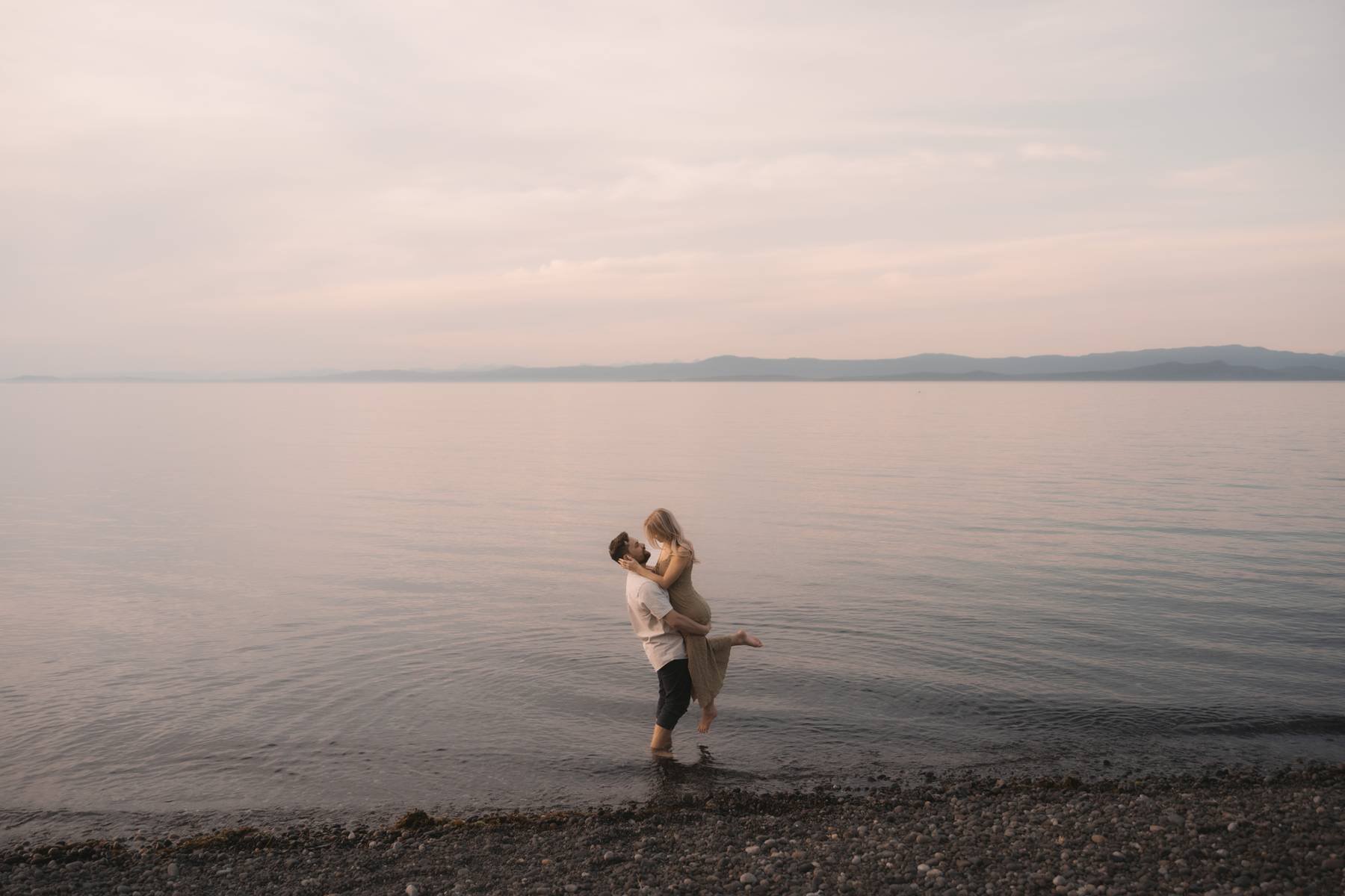 Couple in the ocean during sunset engagement session near Parksville, Vancouver Island, romantic beach moment
