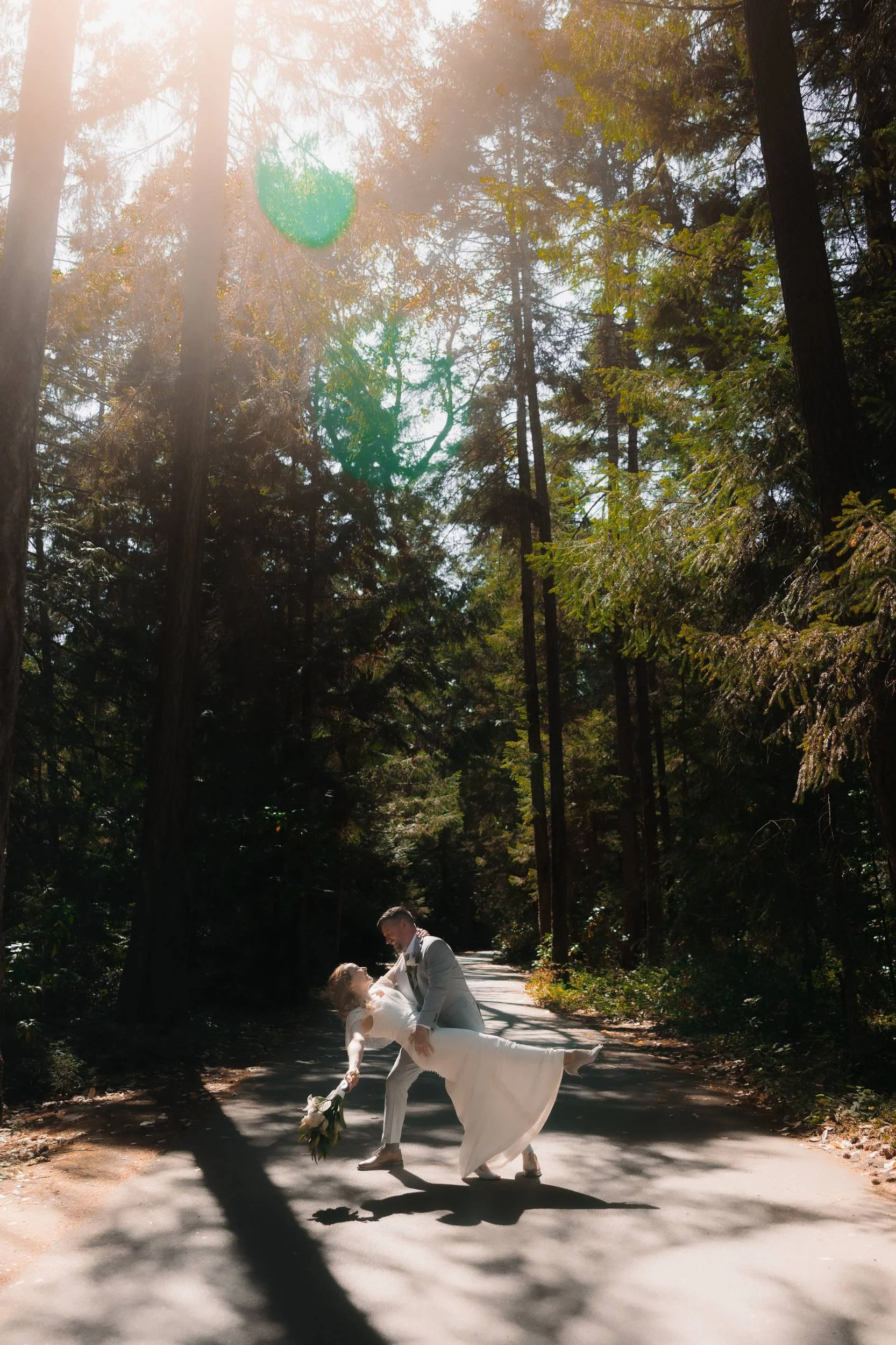 Couple sharing a playful wedding portrait in the forest at Tigh-Na-Mara in Parksville