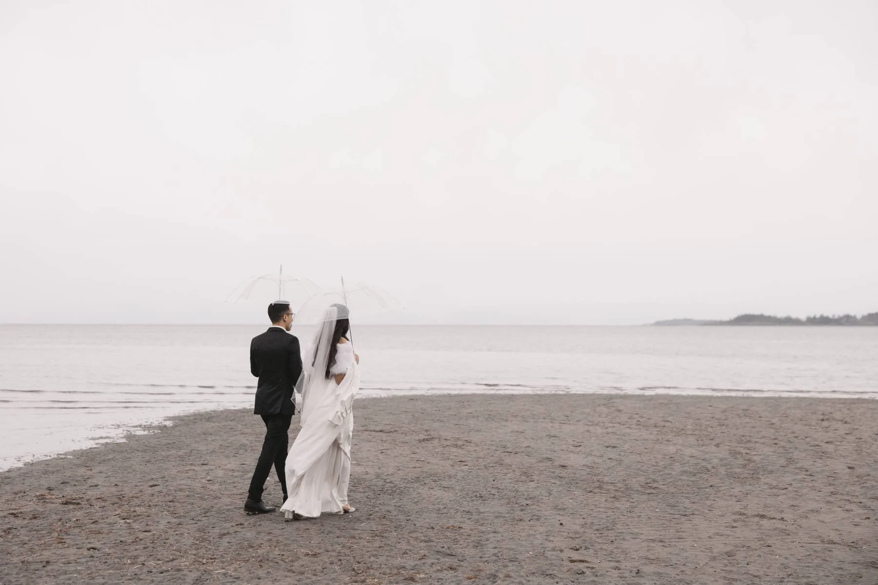 Bride and groom walking along the beach during a Parksville wedding on Vancouver Island