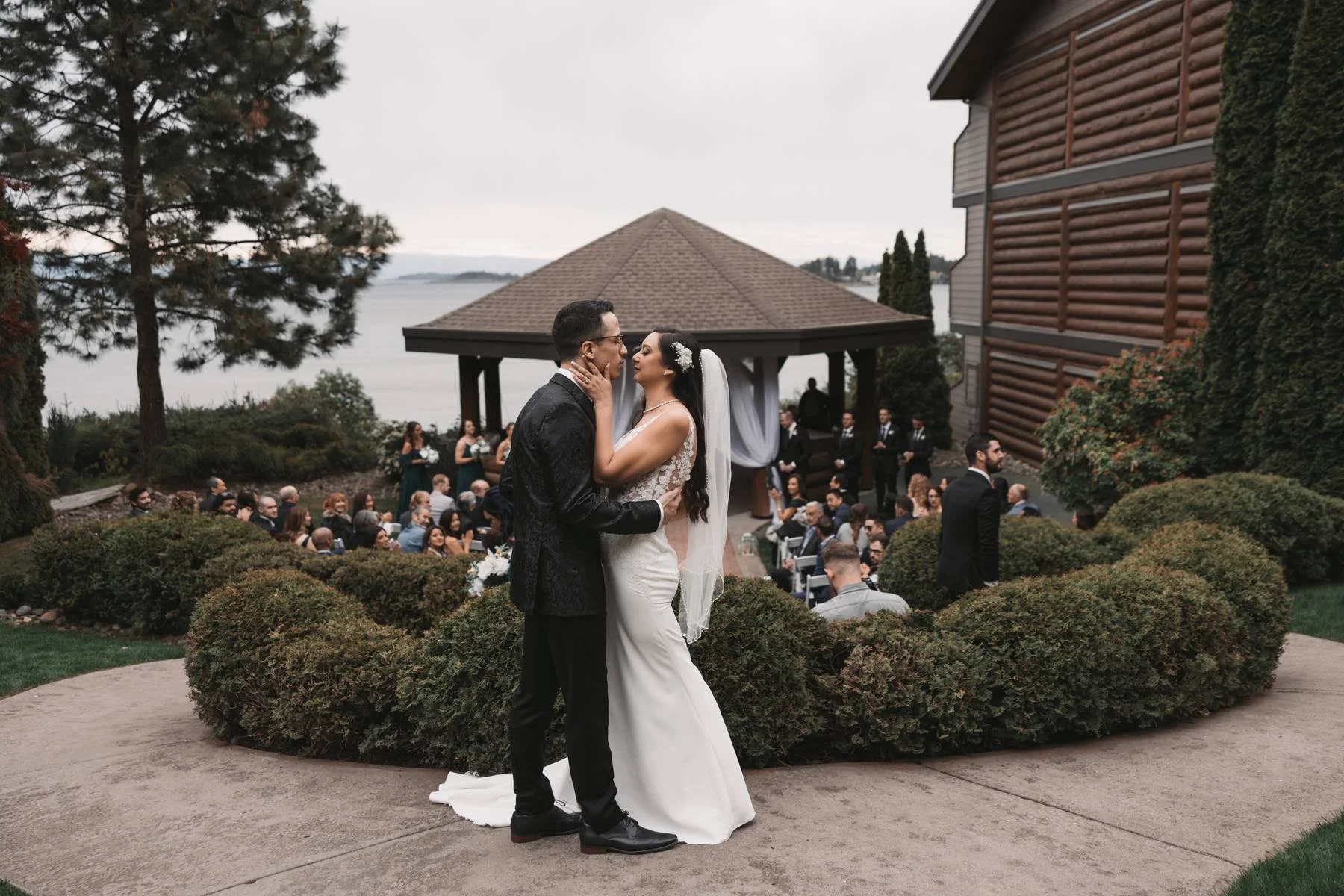 Bride and groom kissing during an oceanfront wedding ceremony at Tigh-Na-Mara Seaside Spa Resort in Parksville, British Columbia