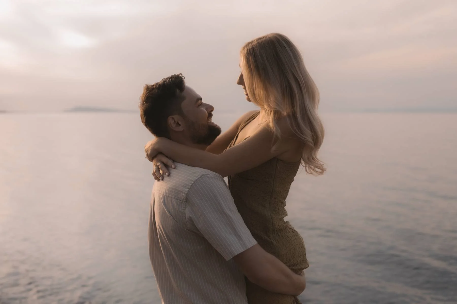 Couple embracing in the ocean at sunset in Parksville, Vancouver Island during a romantic beach engagement session with a local wedding photographer