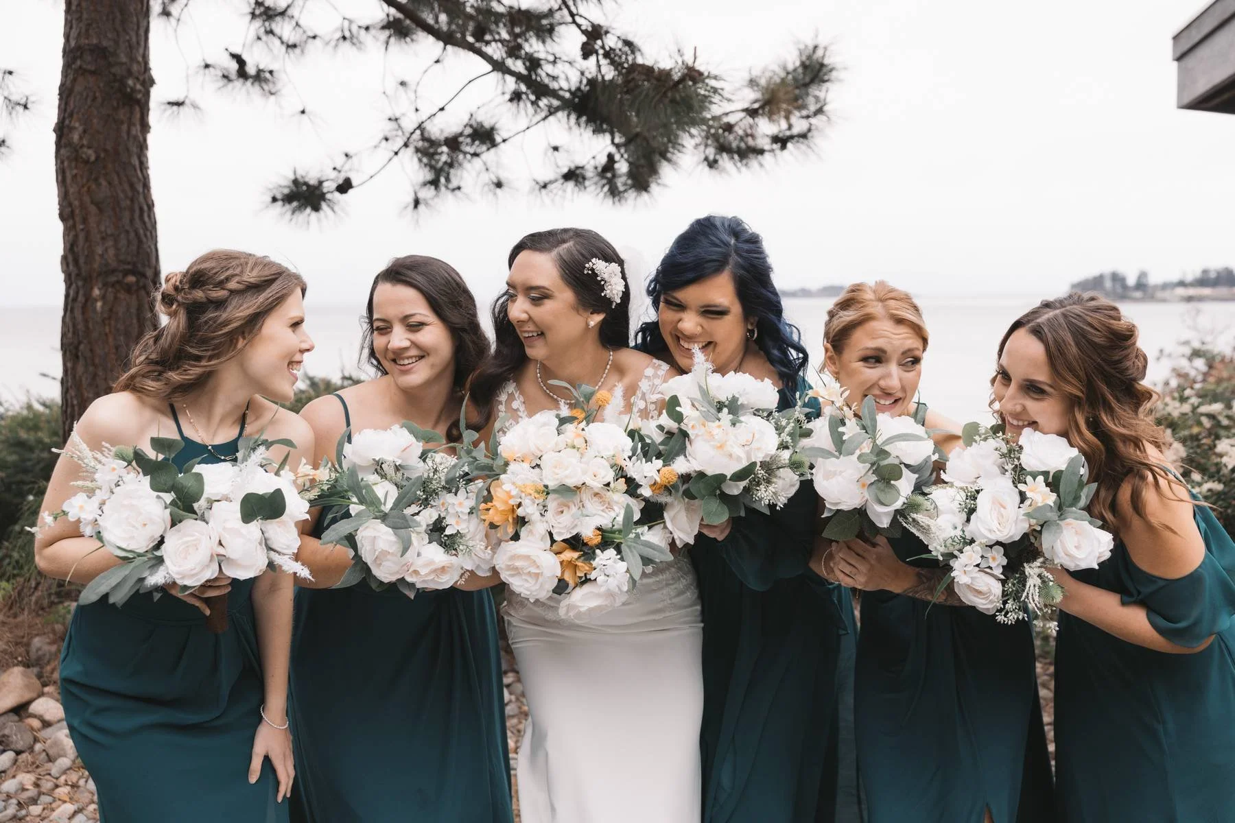 Bride and bridesmaids holding bouquets at Tigh-Na-Mara wedding in Parksville near ocean