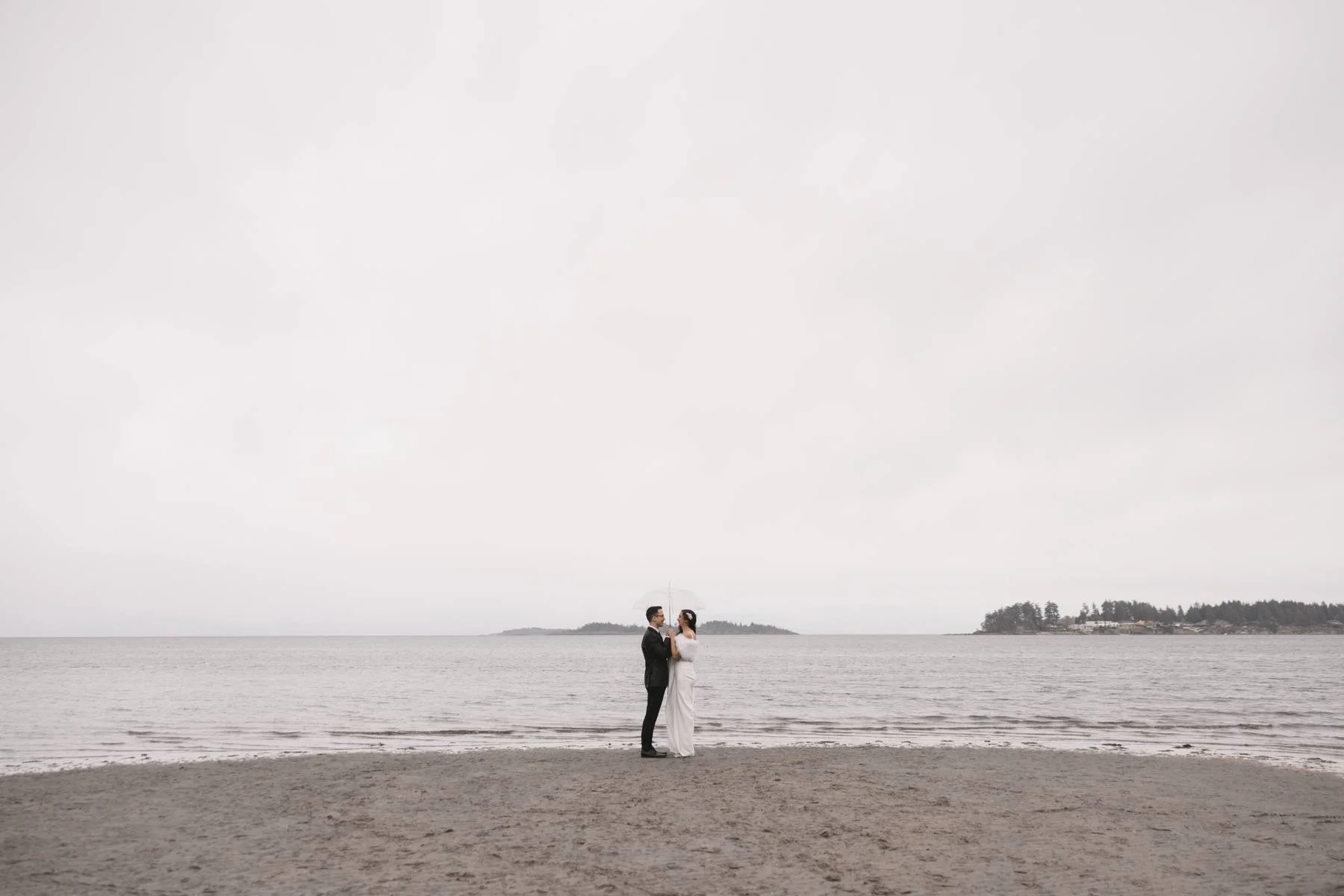 Bride and groom standing on the beach during an oceanfront wedding at Tigh-Na-Mara Seaside Spa Resort in Parksville, British Columbia
