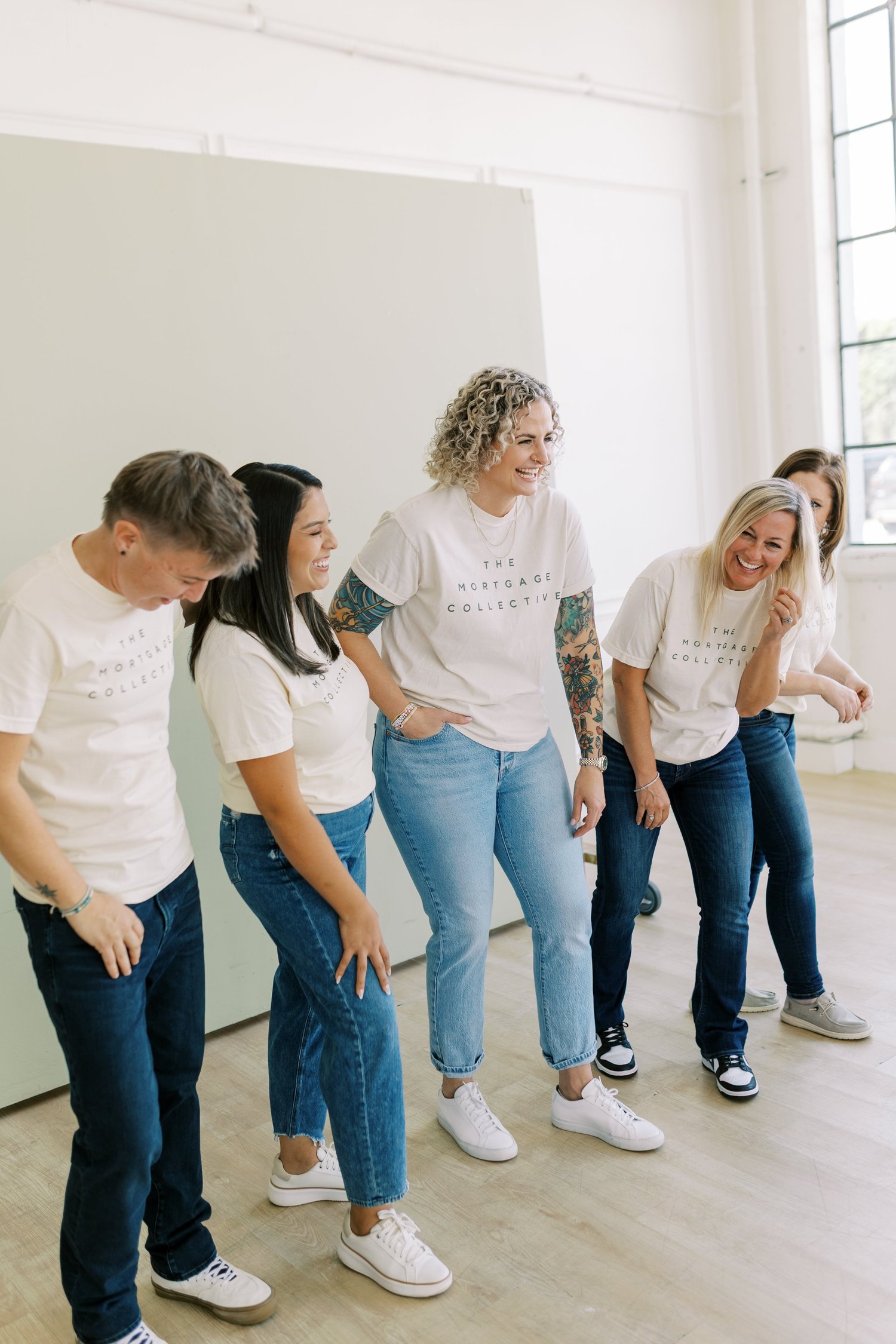 The Mortgage Collective team laughing together in a bright office