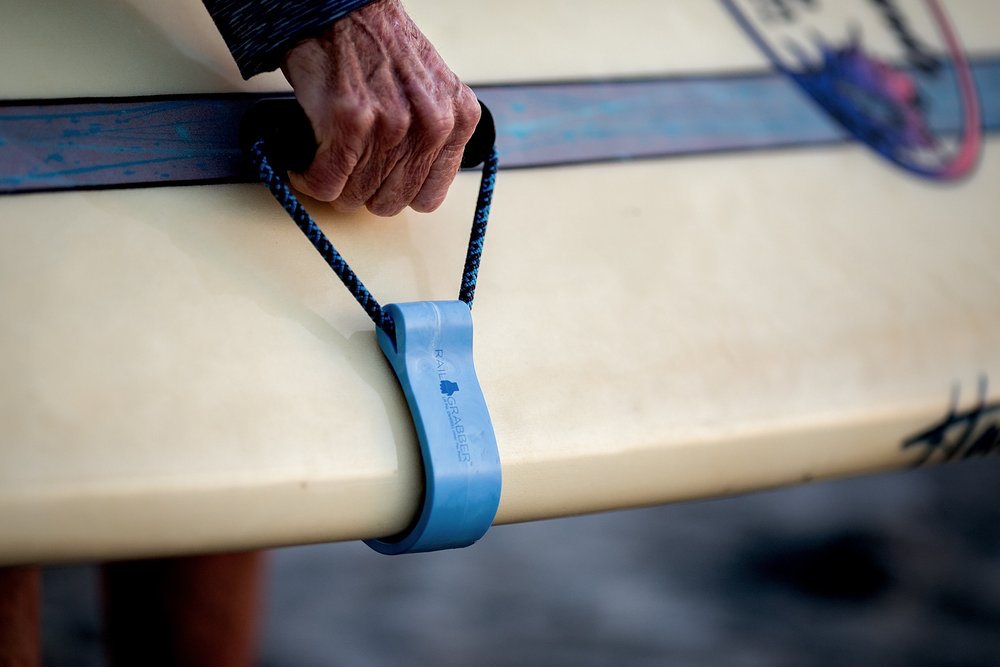 Linda Benson created the Rail Grabber to make it easier on your hands and arms to transport longboards to the beach. 