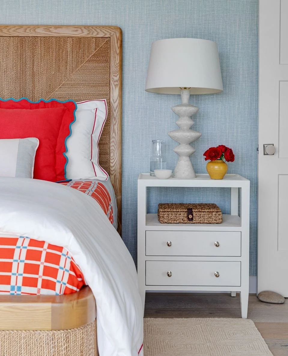 The primary bedroom carries the color story of our Block Island Project into a softer, more restful space.⁠
⁠
Pale blue grasscloth, natural textures, and warm wood create a relaxed backdrop, while that pop of red brings in the playful spirit found th