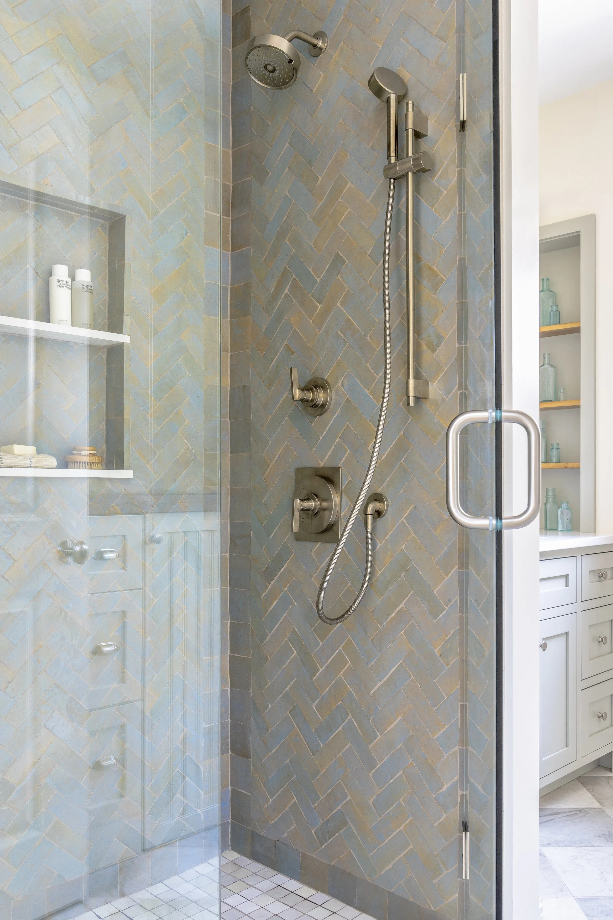 Renovated coastal bathroom with glass shower and blue patterned tile in the Jerusalem Heights beach house.