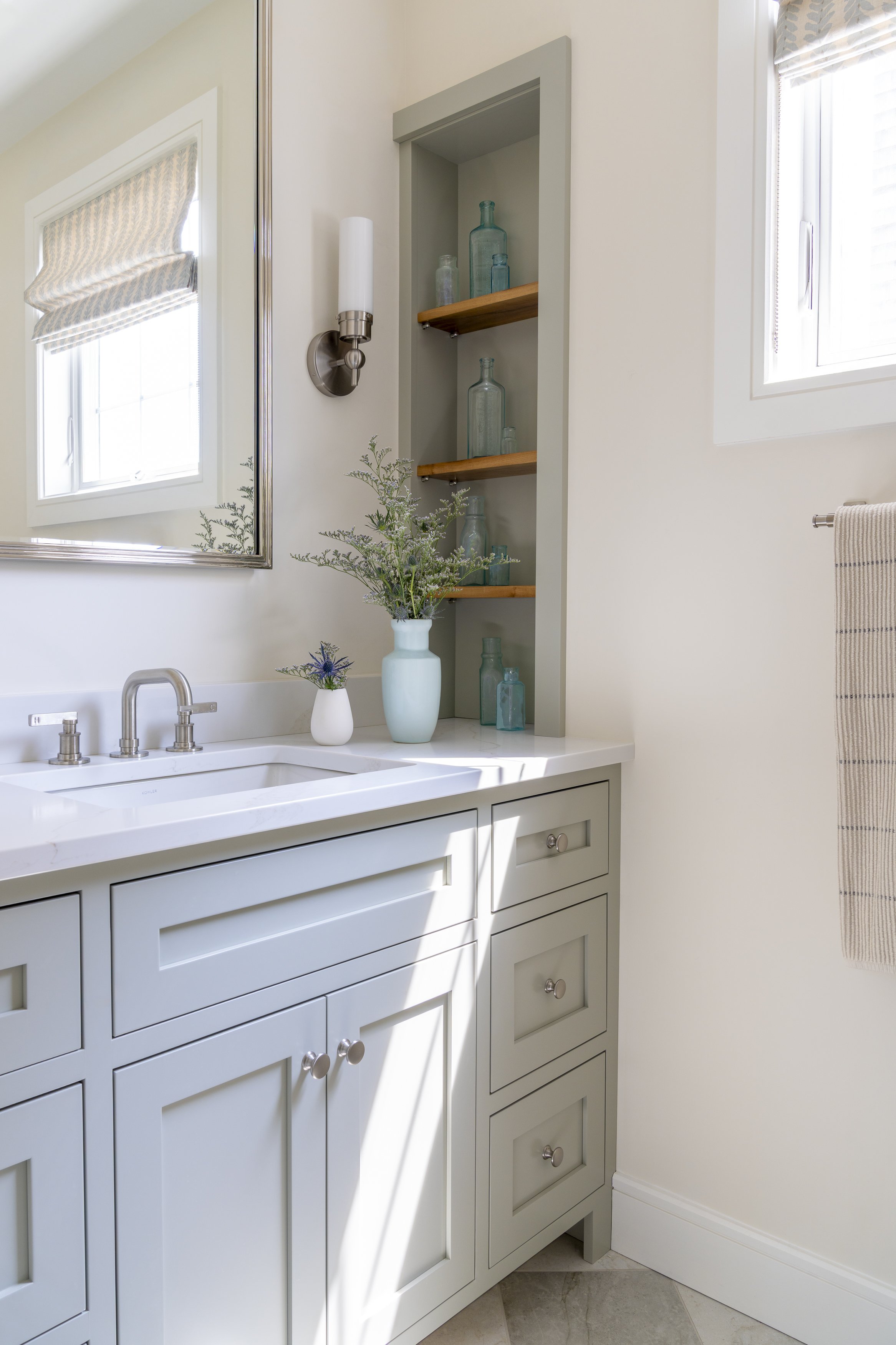 Renovated bathroom with blue-gray vanity, open wood shelving and coastal details in Narragansett, Rhode Island.