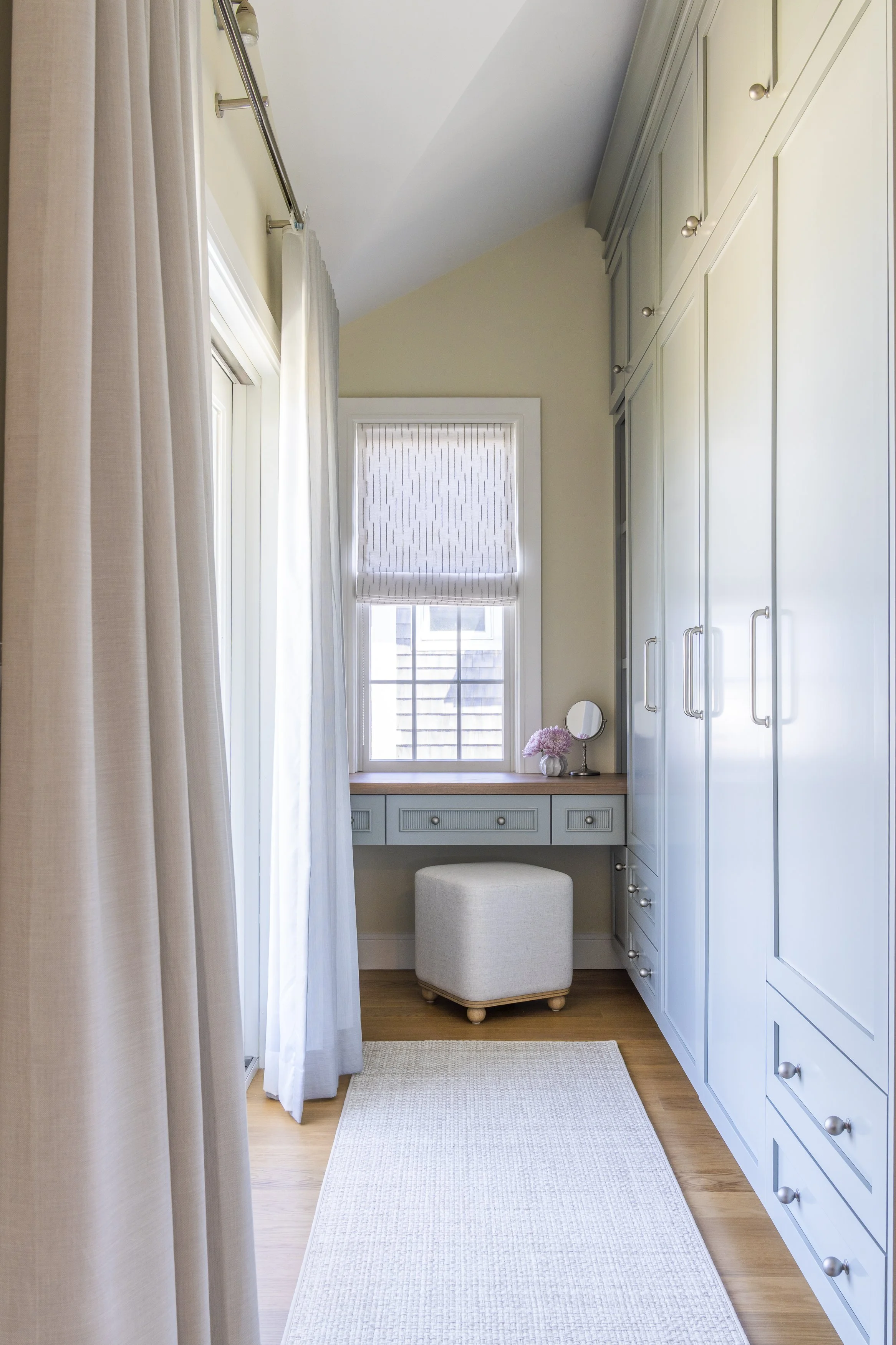 Custom beach house changing room with blue-gray cabinetry, built-in vanity and storage in Narragansett, Rhode Island.