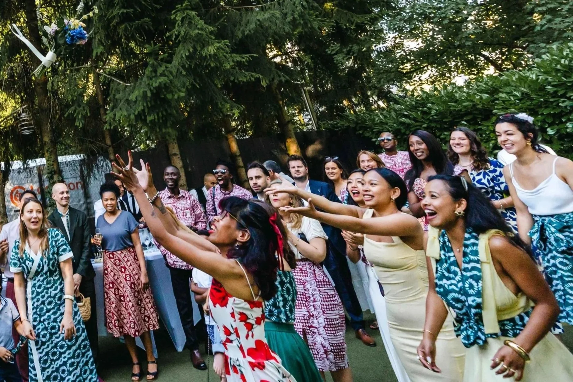 Groupe de personnes souriantes et en mouvement lors d'une célébration en extérieur