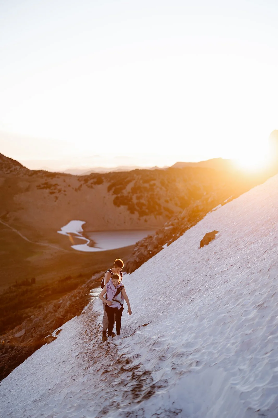 couple hiking on the snow for their engagement photos at mount rainier