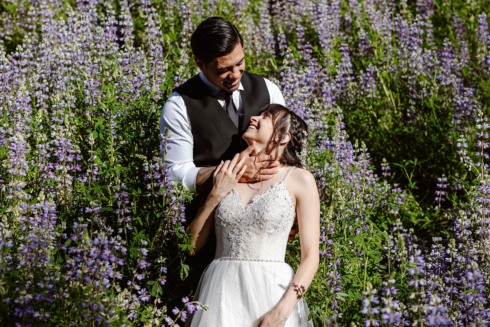 elopement couple standing in a field of lupines for their elopement by the washington coast