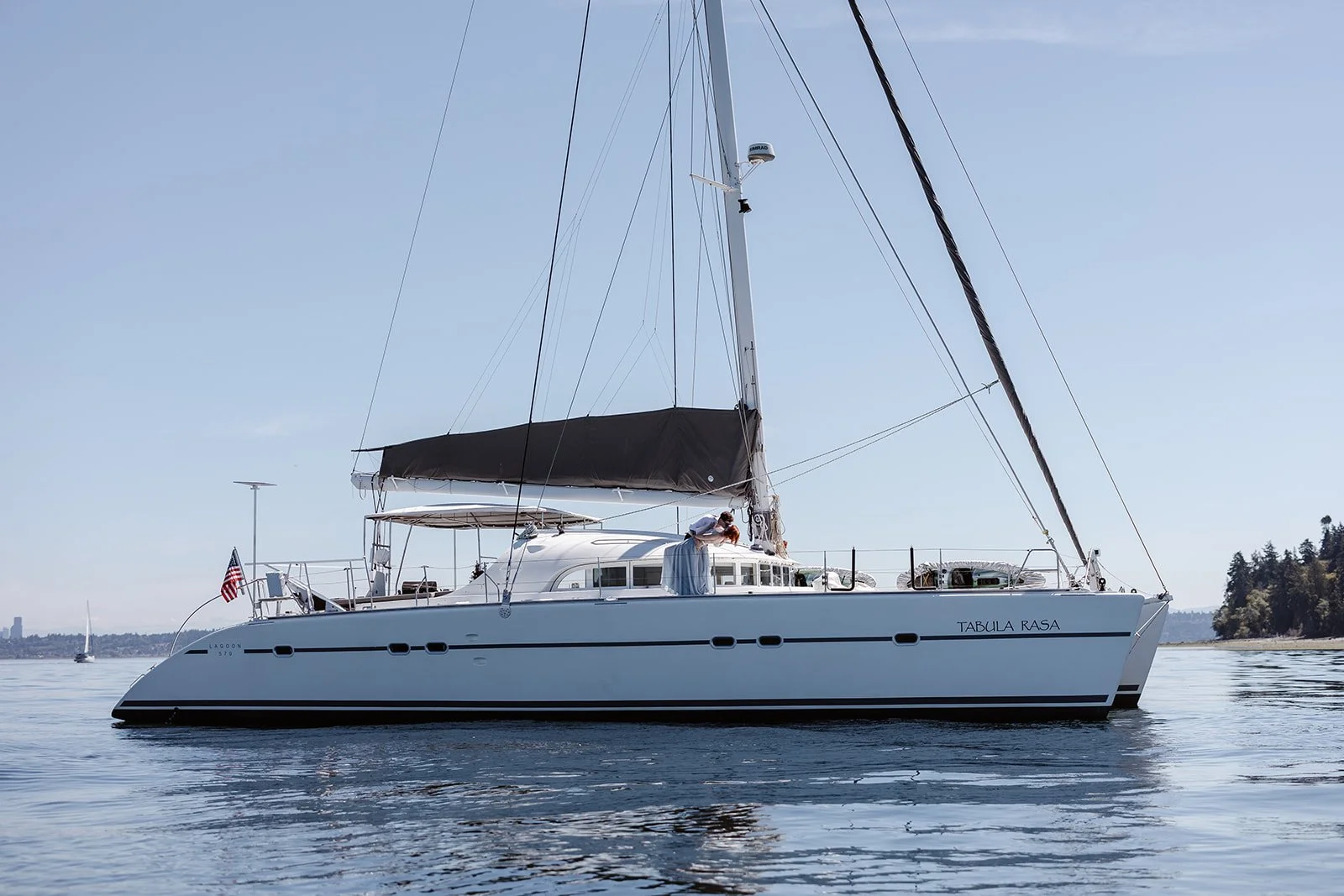 elopement couple posing on their sailboat for their adventure elopement in washington