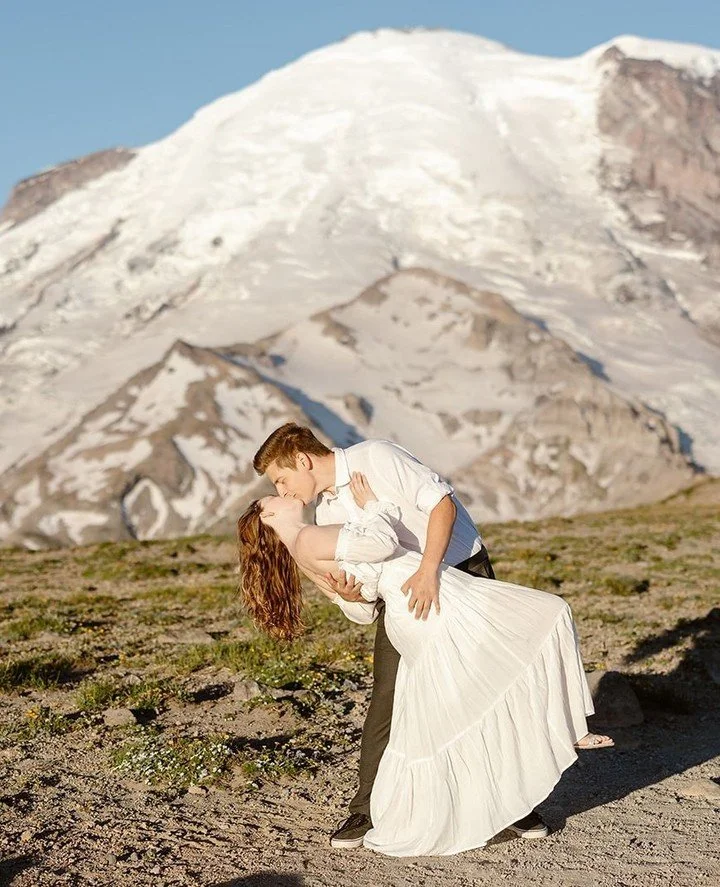 As a Washington engagement + elopement photographer, I&rsquo;ve photographed couples ankle‑deep in Puget Sound tide pools, twirling near Mt. Rainier wildflower meadows, wrapped in Pendleton blankets on an Olympic Coast bluff, and dressed to the nines