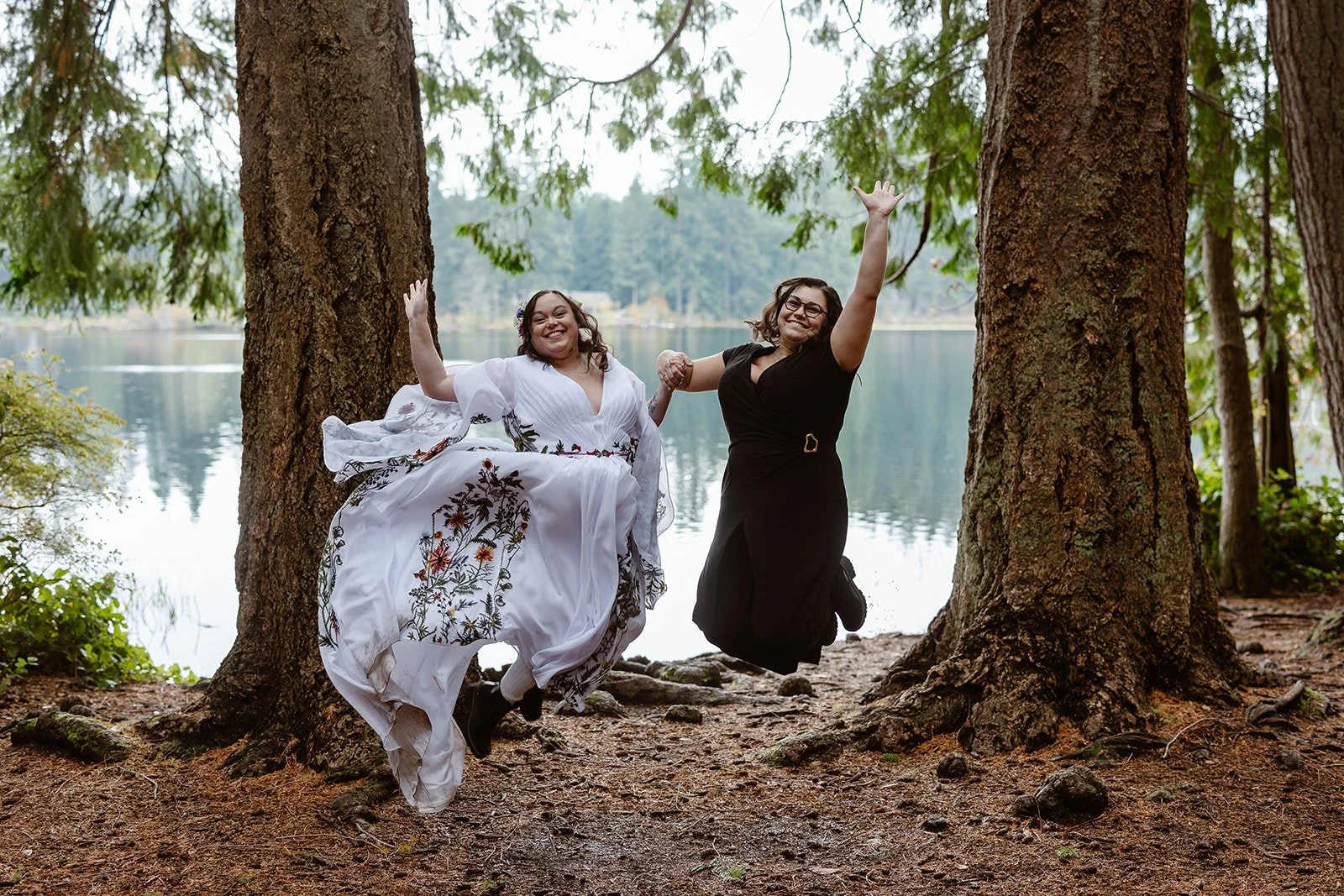 washington couple jumping in the air for their elopement in the forest