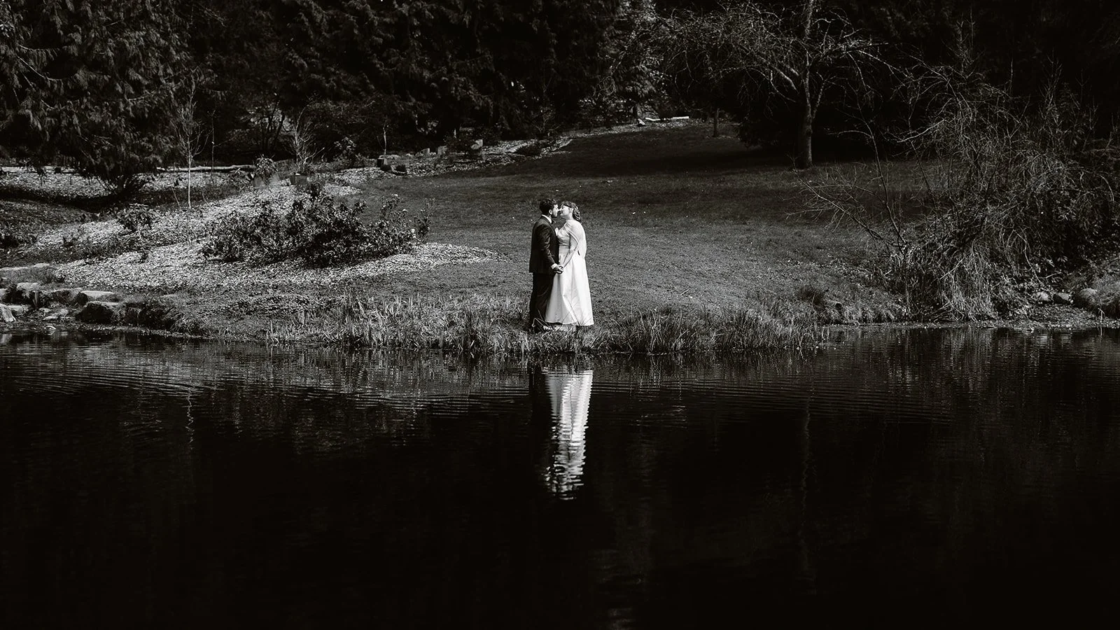 wedding couole kissing at the pond at the seattle arboretum
