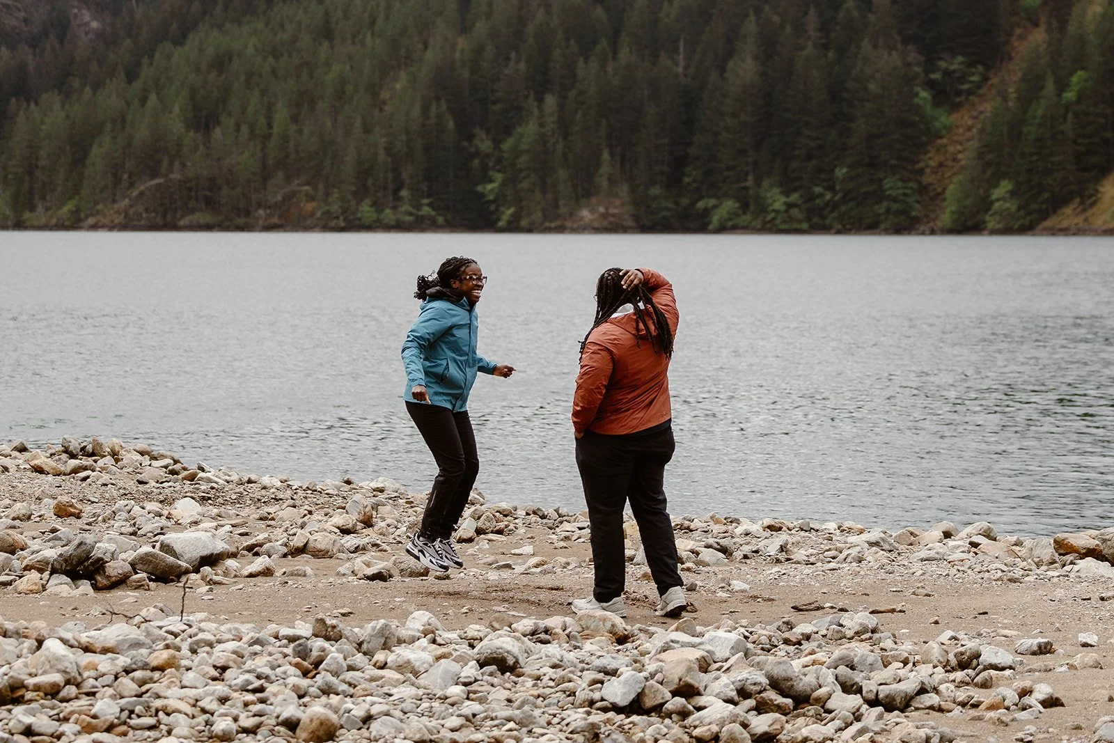 woman jumping in the air after saying yes during her surprise proposal in north cascades