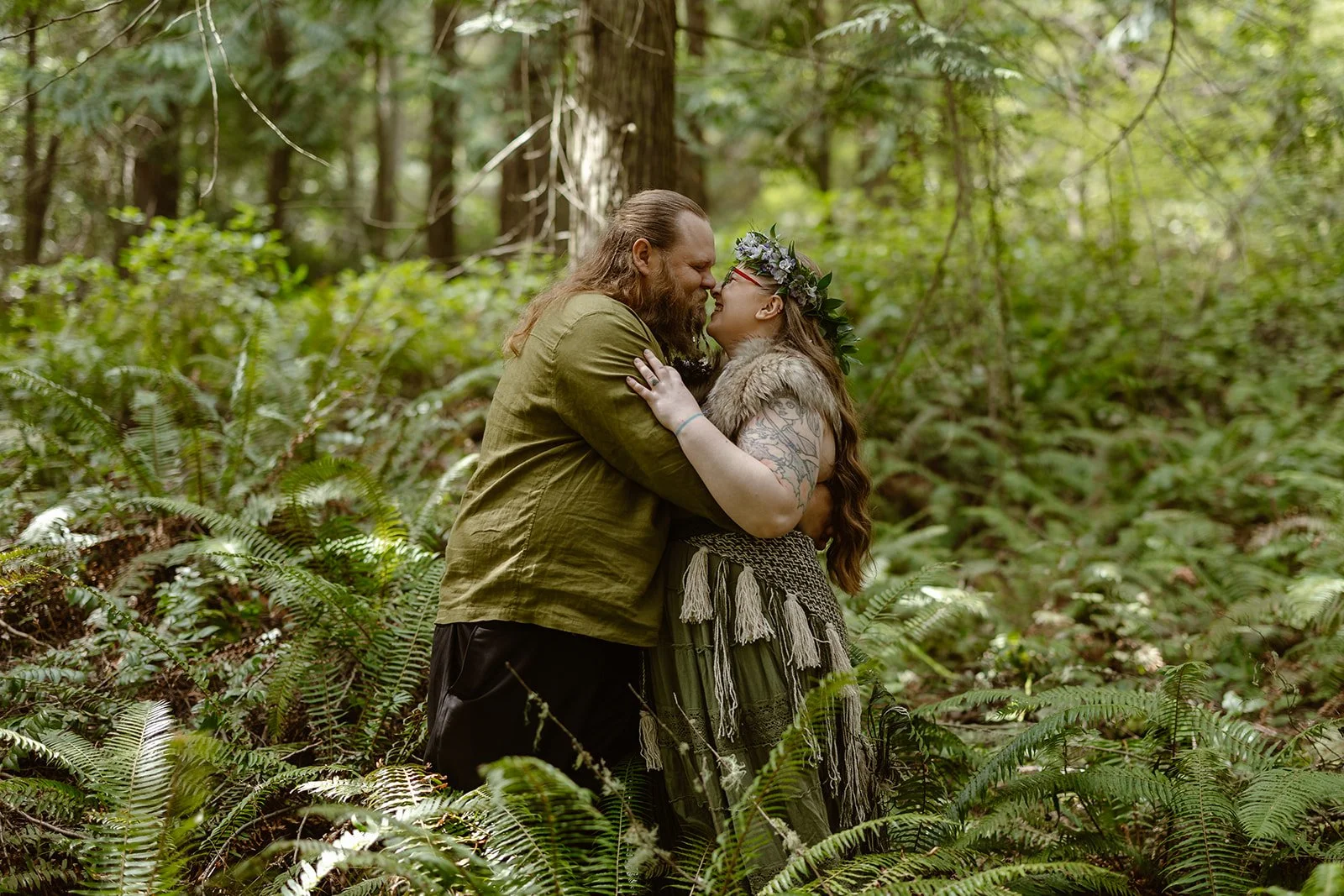 wedding couple kissing by ferns at deception pass state park