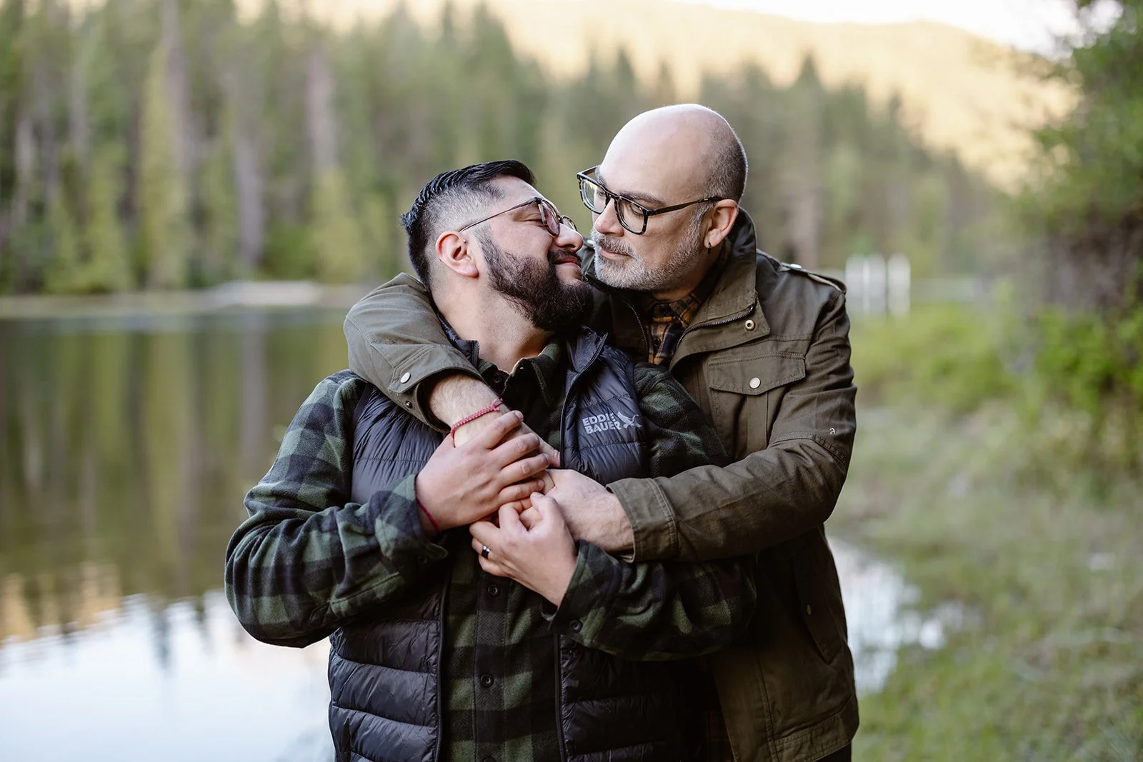 Gay couple smiling at each other for their engagement session in seattle