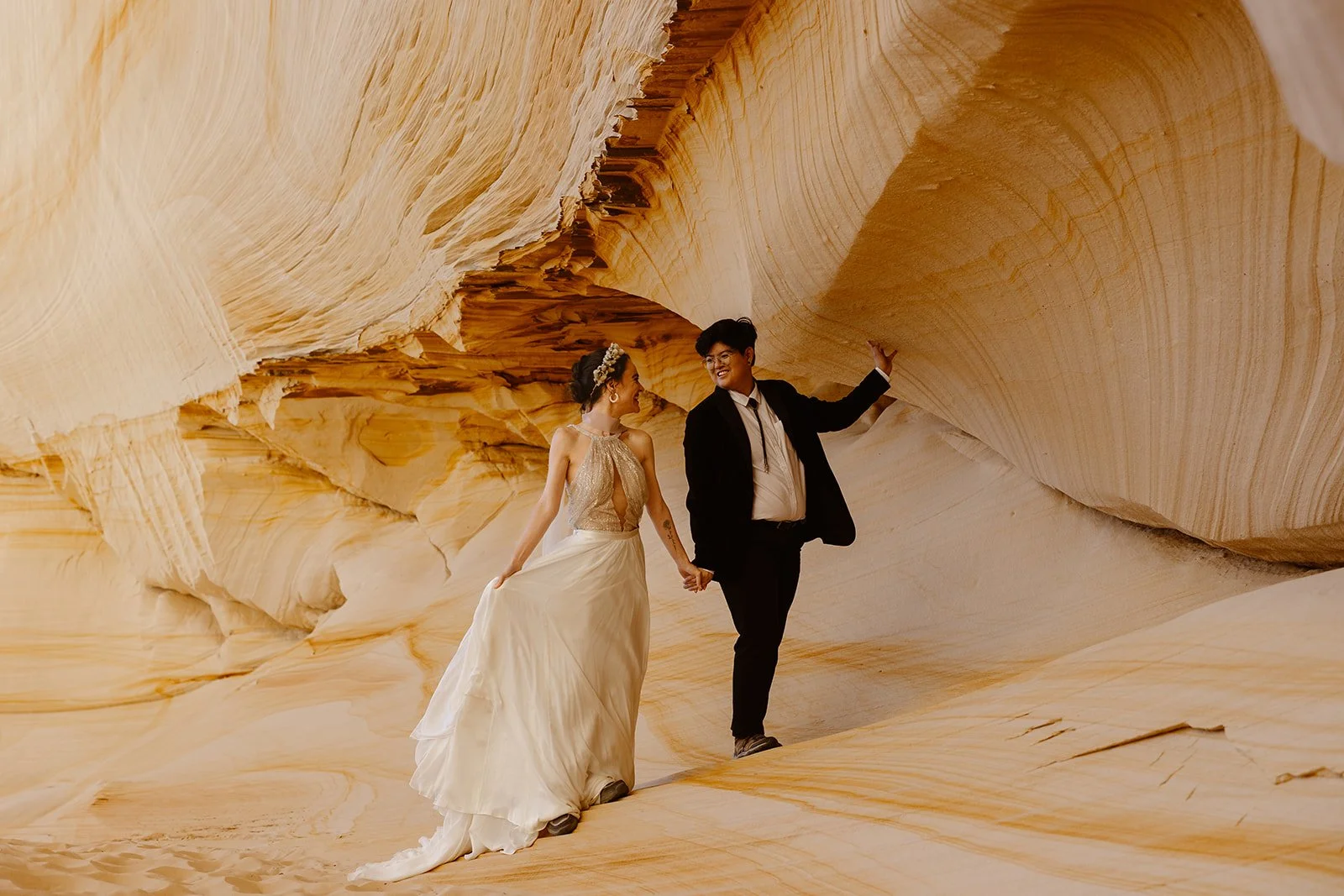 elopement couple walking along some sand dunes for their Arizona Elopement