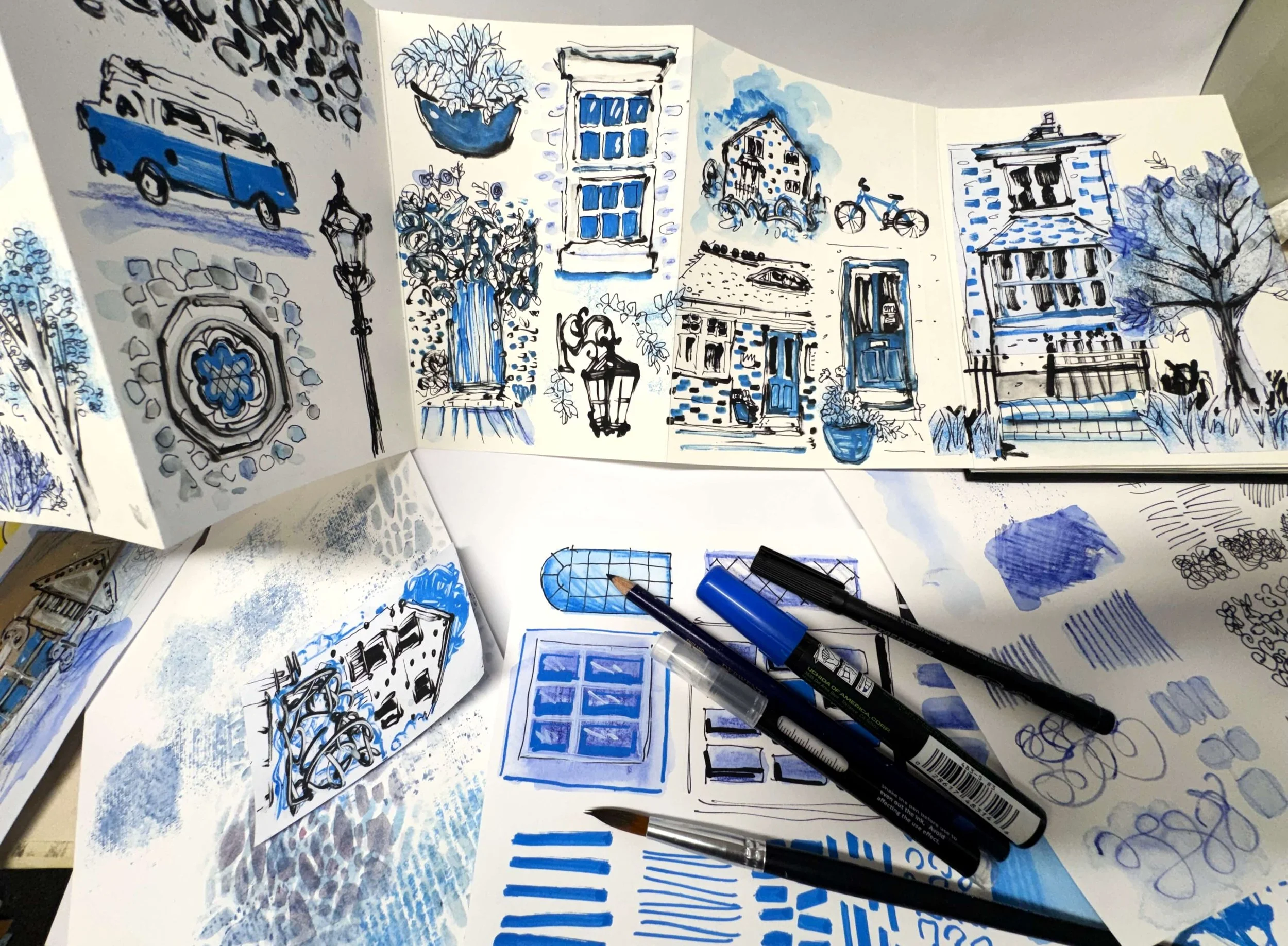 Sketches in a sketch book of urban elements in black in and blue ink