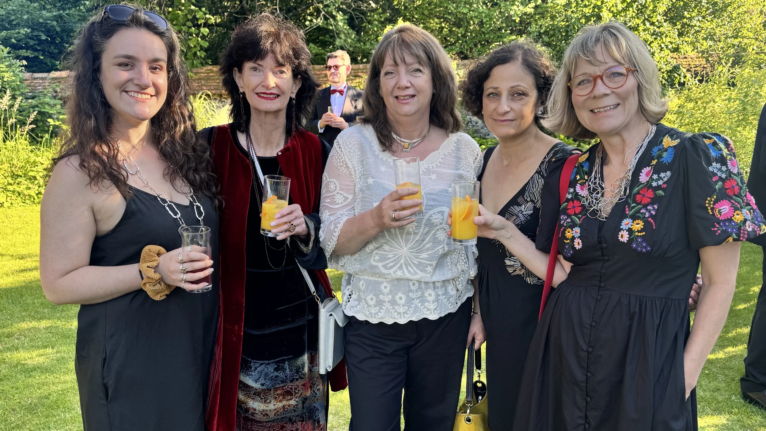 Jenny Muncaster and fellow Colour Factory artists smiling and holding cocktails in the walled garden at Winchester Cathedral during the Winchester Business Excellence Awards 2026 ceremony.