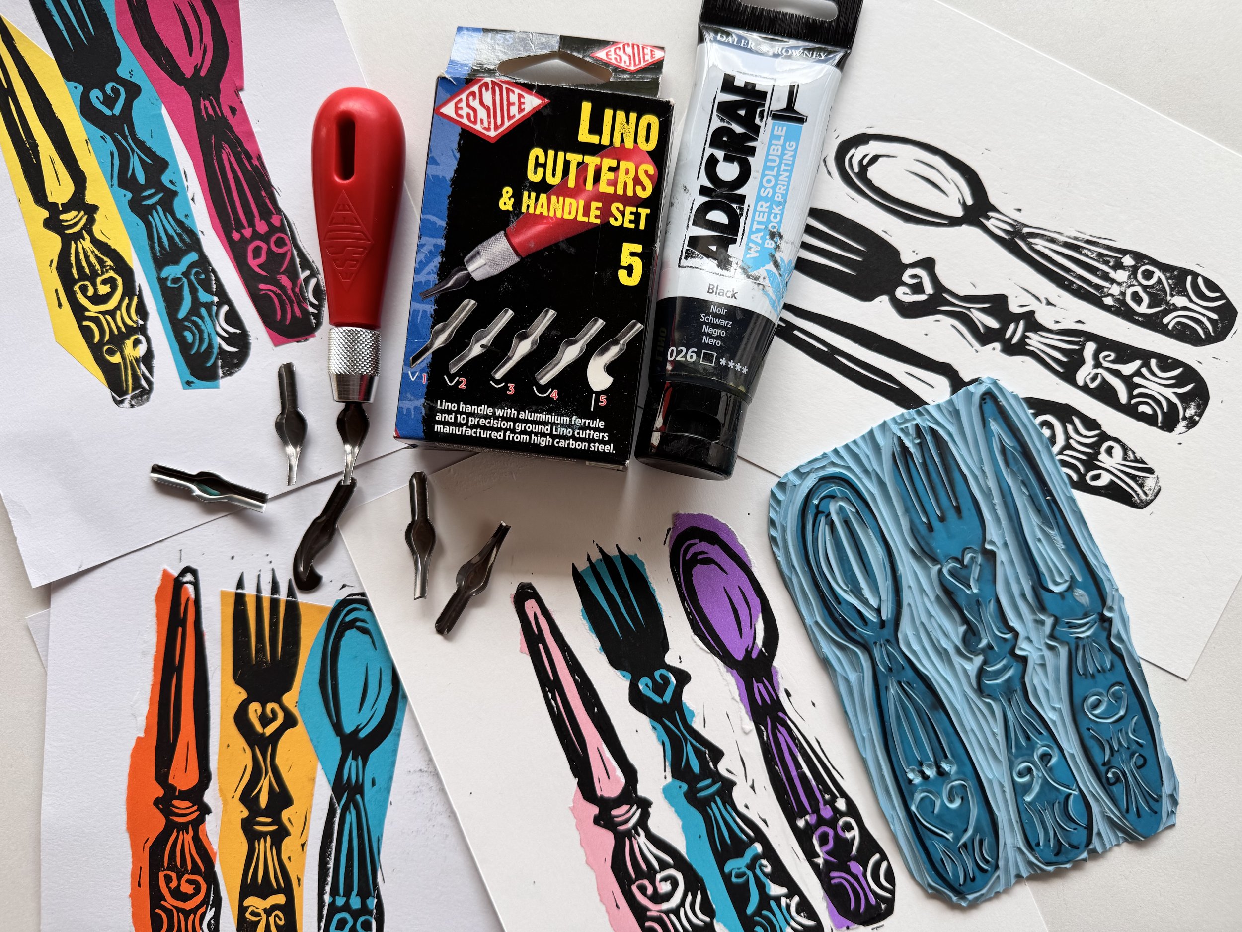 lino cutting tools on colourful lino art prints