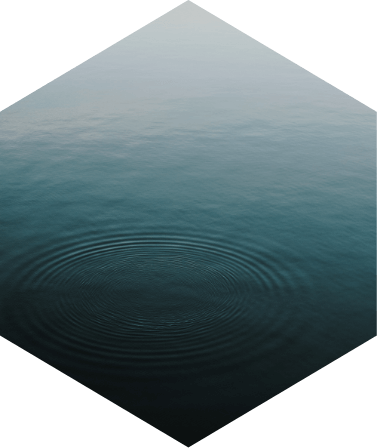 Ein ruhiger Wassersee mit kreisförmigen Wellen an der Oberfläche.