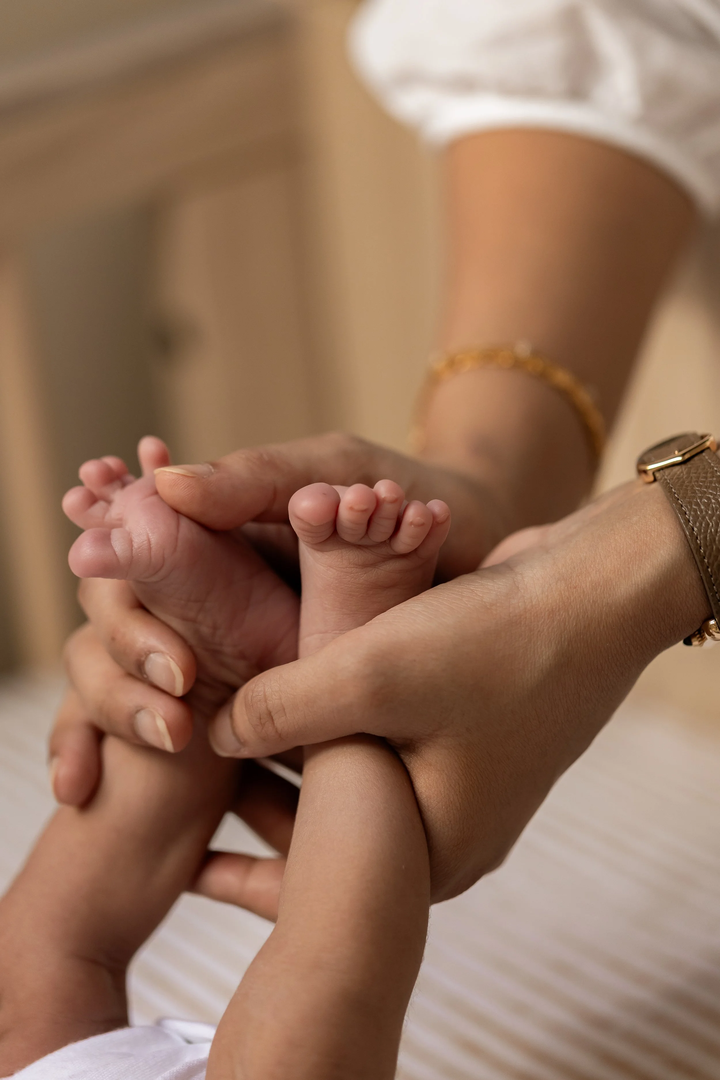 Tiny newborn feet being held in mother’s hands during a natural newborn photography session