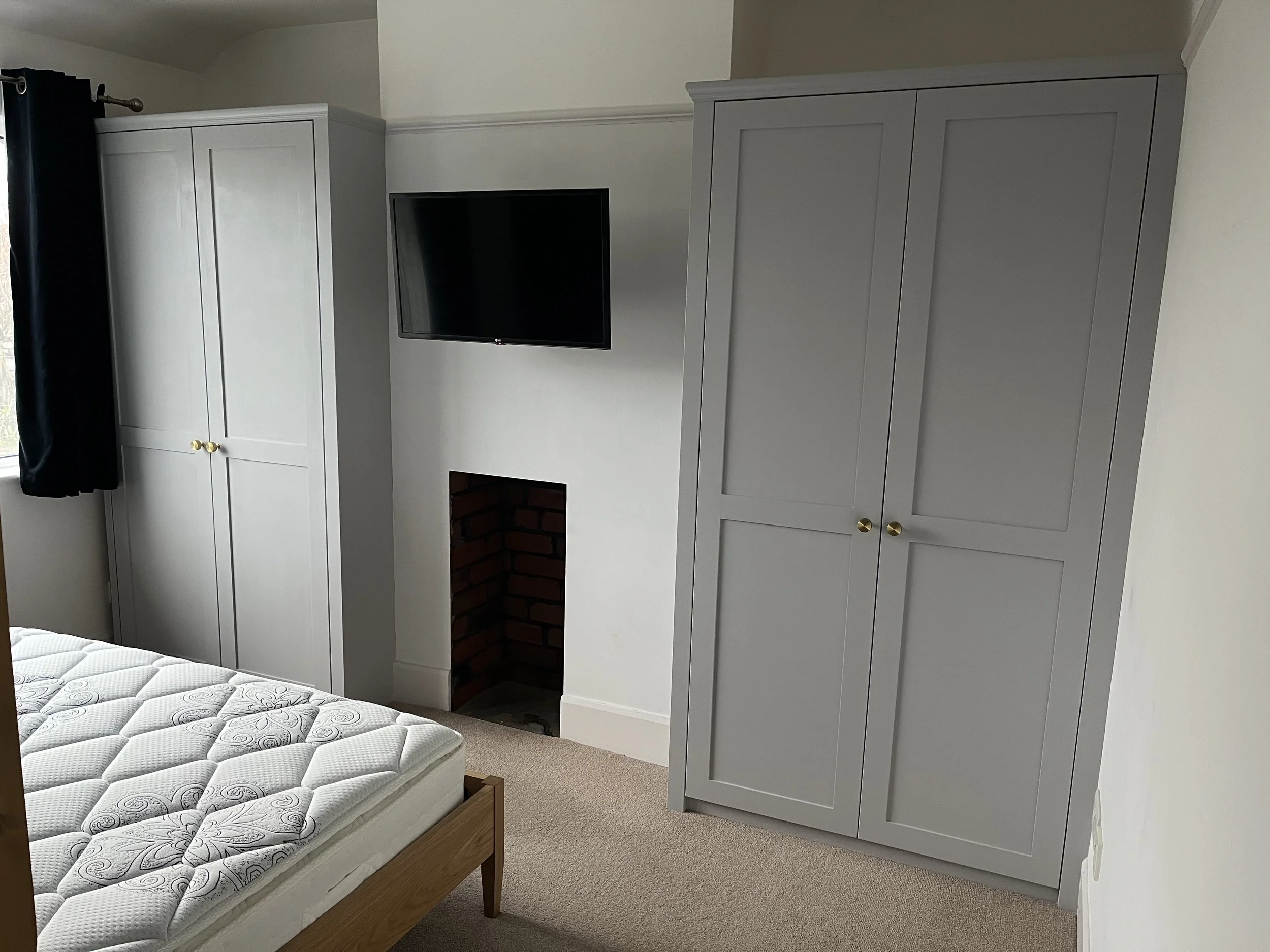Shaker style wardrobes with internal drawers. Moisture-resistant MDF cabinets in a grey painted finish, with brass door knobs and Blum hardware.