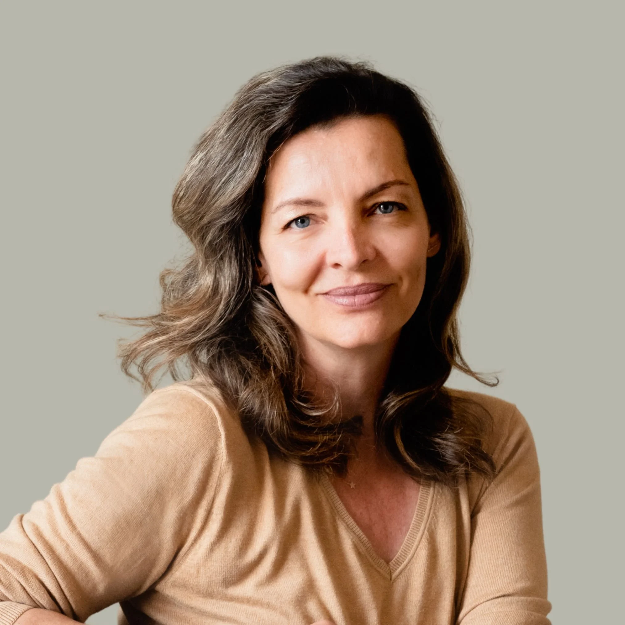 Woman with brown hair smiling, wearing a black top and gold necklace, who is Laura Malandrino, an associate therapist at Lisa Chen & Associates..