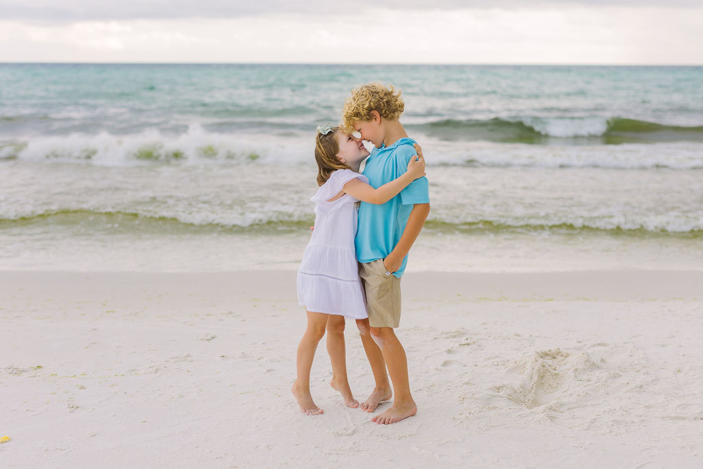Two children hugging on the beach.