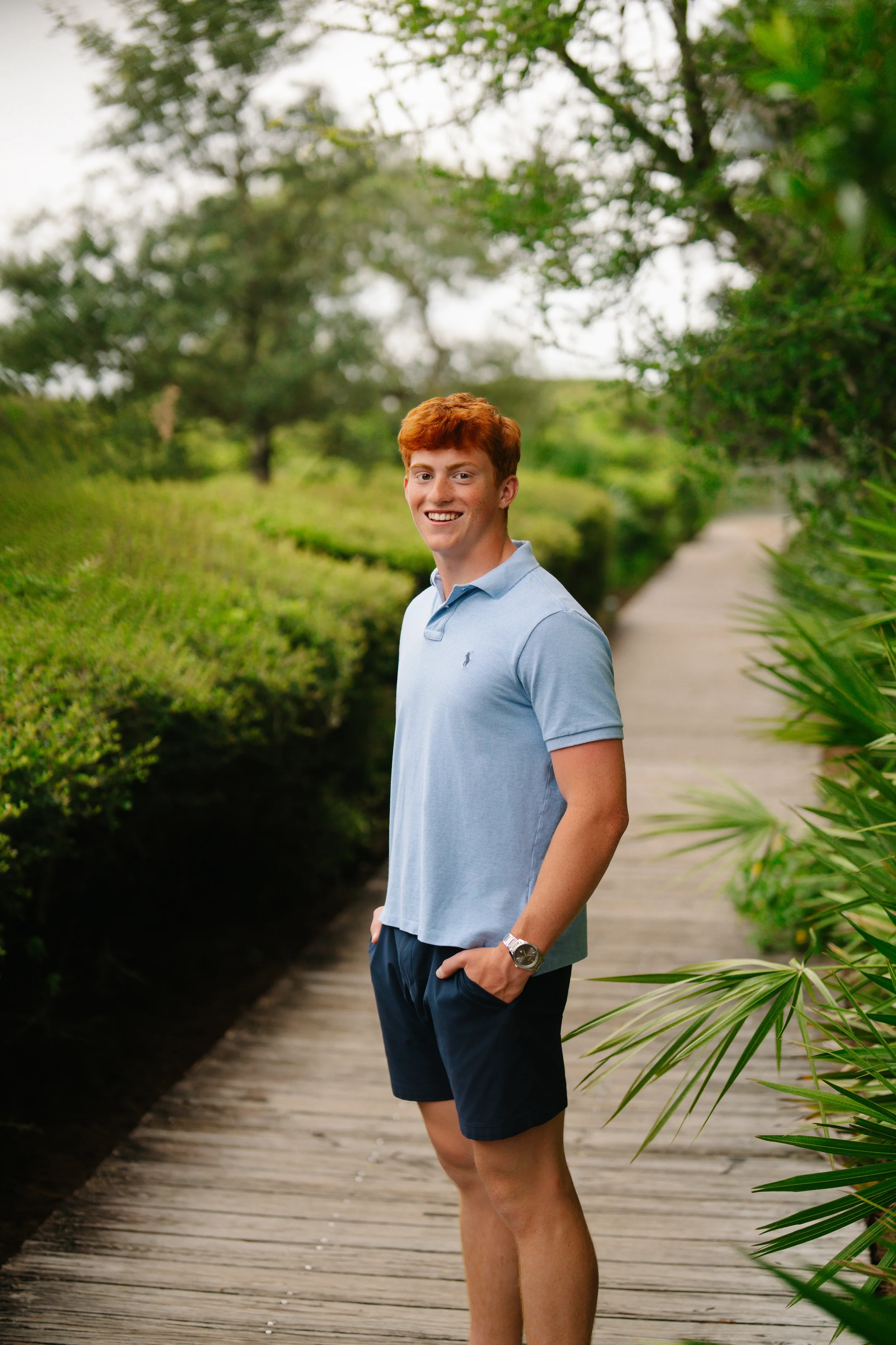 Freeport portrait photographer capturing a young man walking along a garden path