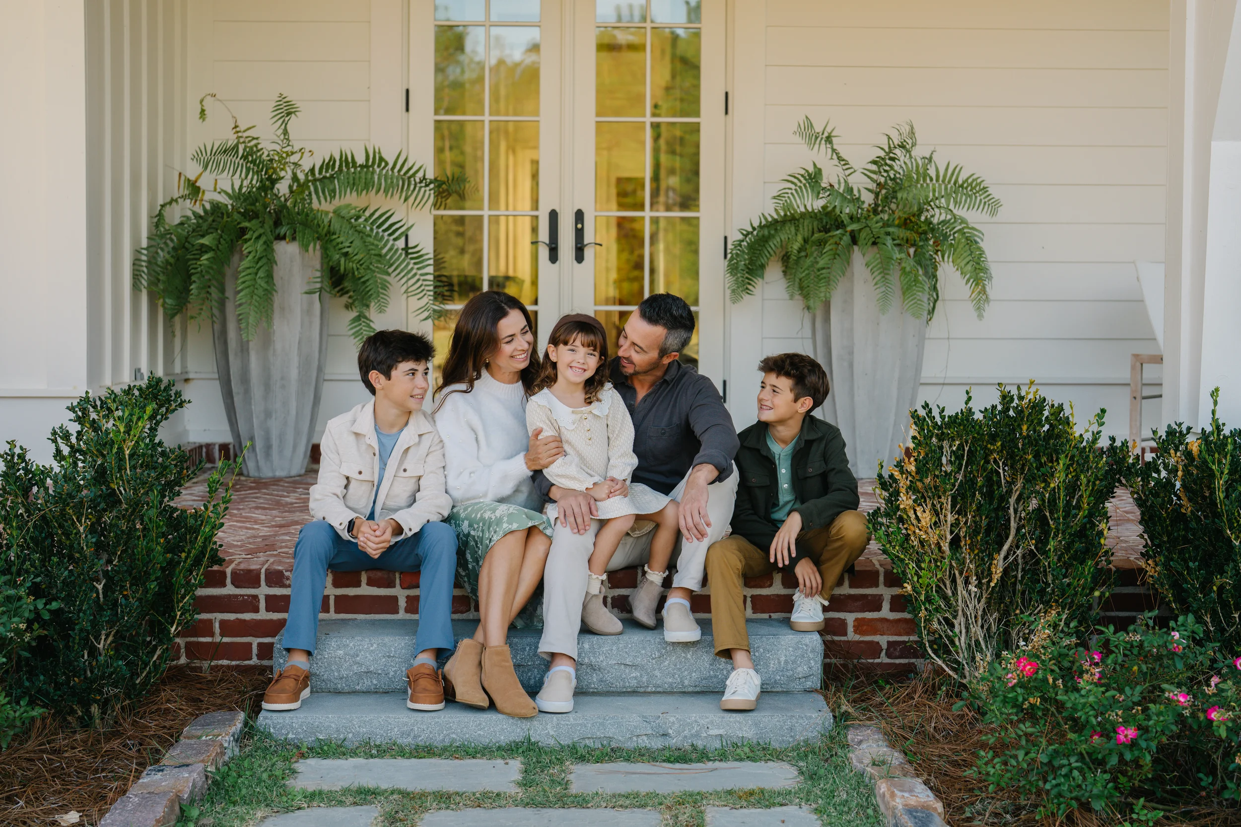 Freeport family photographer capturing siblings seated together on a front porch
