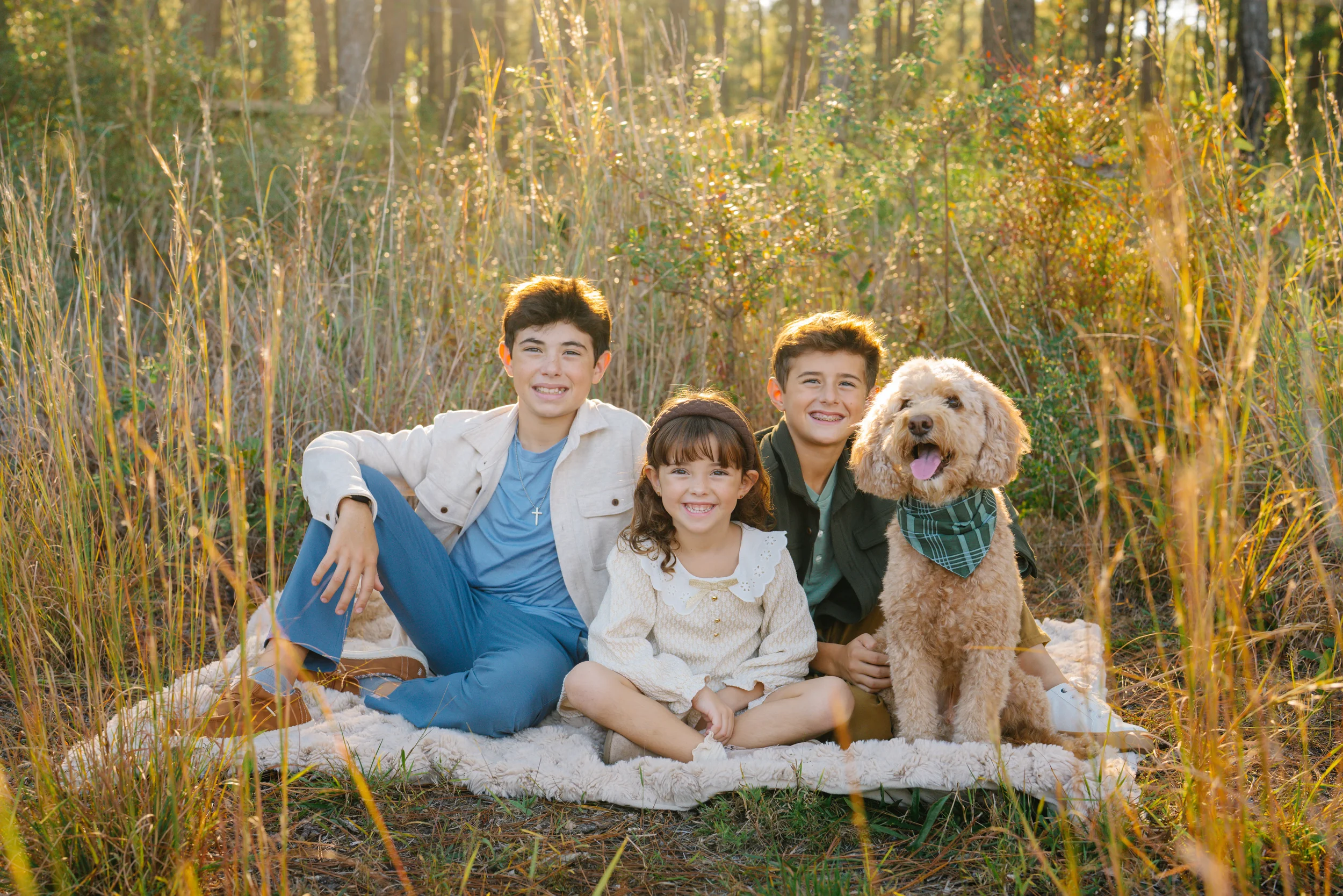 Freeport family photographer capturing siblings with their dog in a wooded setting